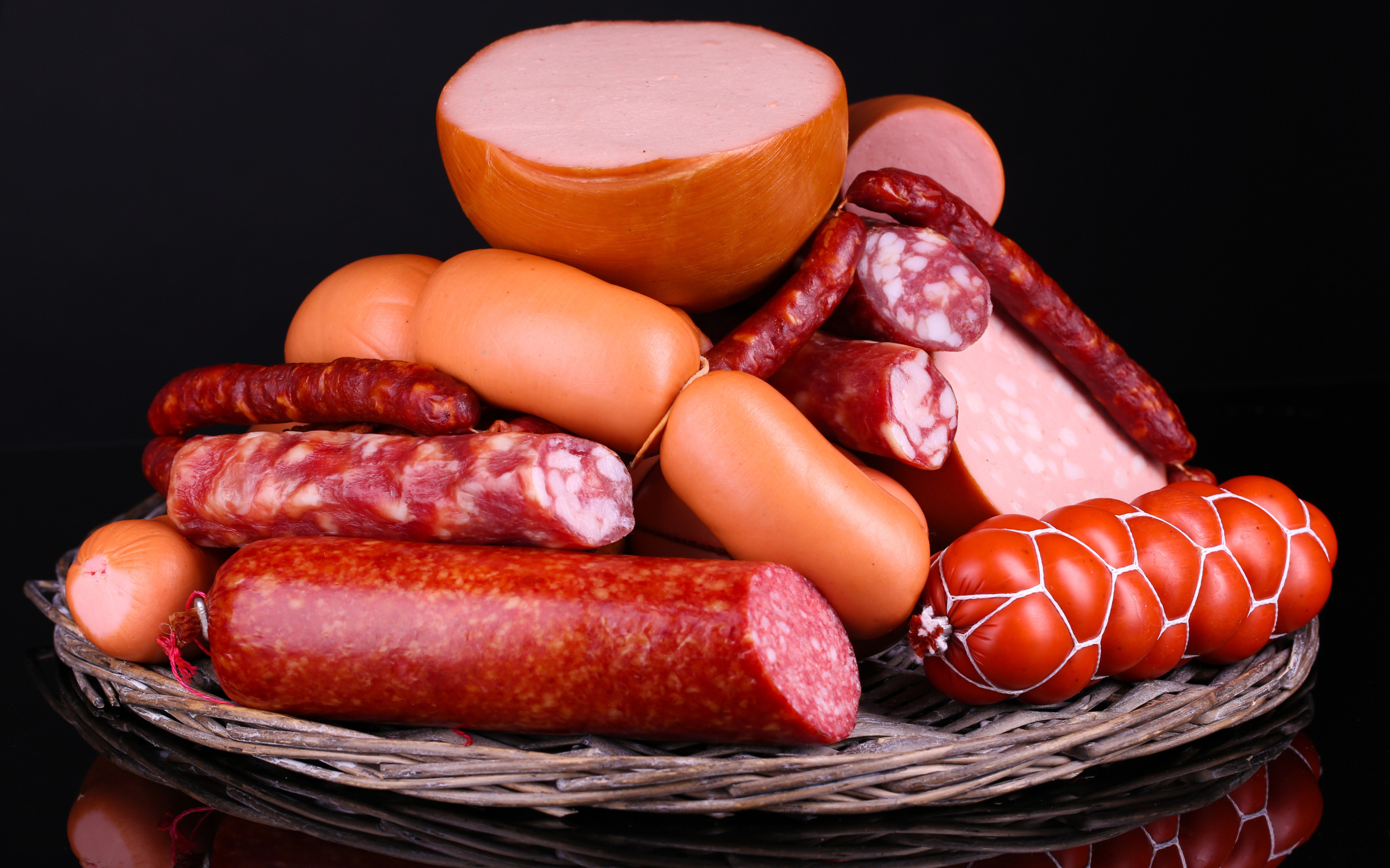 Мясные продукты колбасы и сосиски на черном фоне