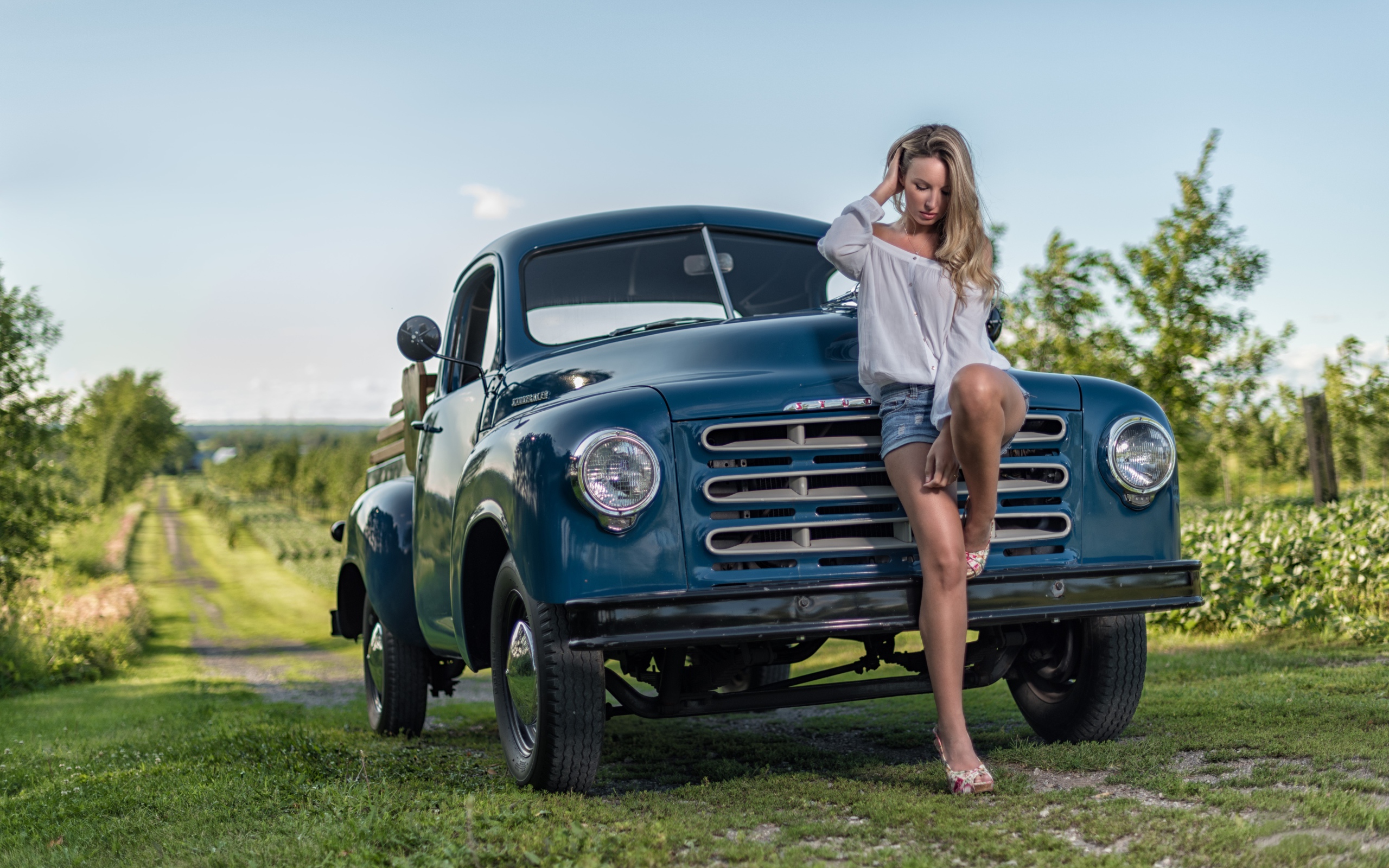 Молодая девушка стоит рядом с зеленым автомобилем Studebaker Pickup, 1953 года