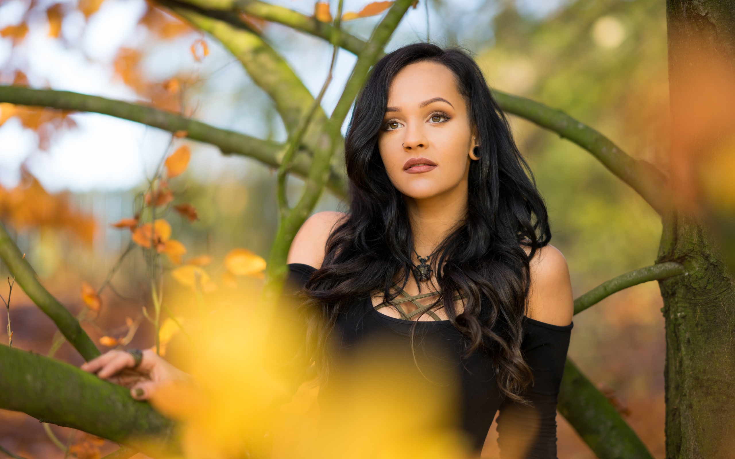 Красивая брюнетка у дерева в черном платье