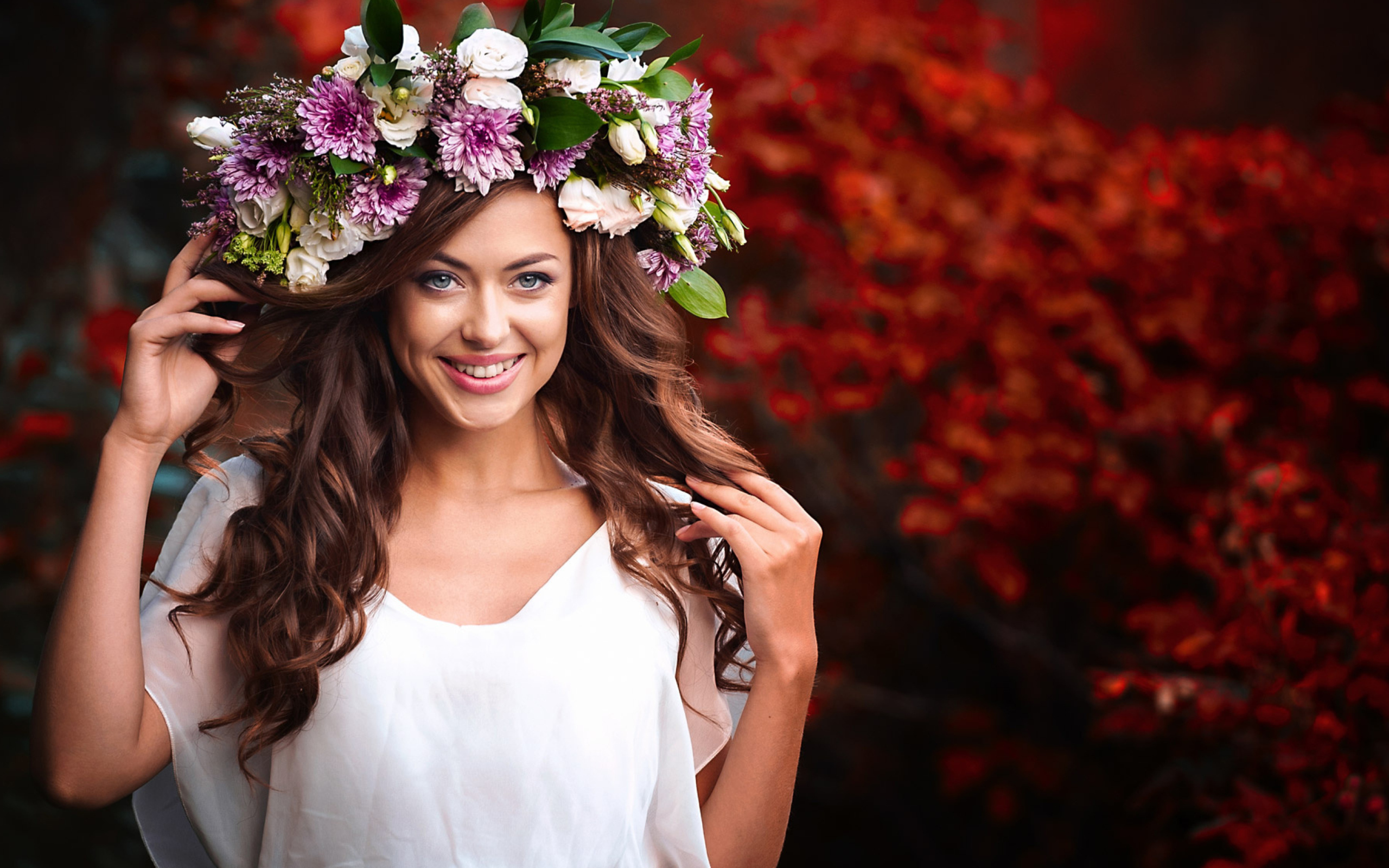 Красивая улыбающаяся девушка с венком из живых цветов на голове 
