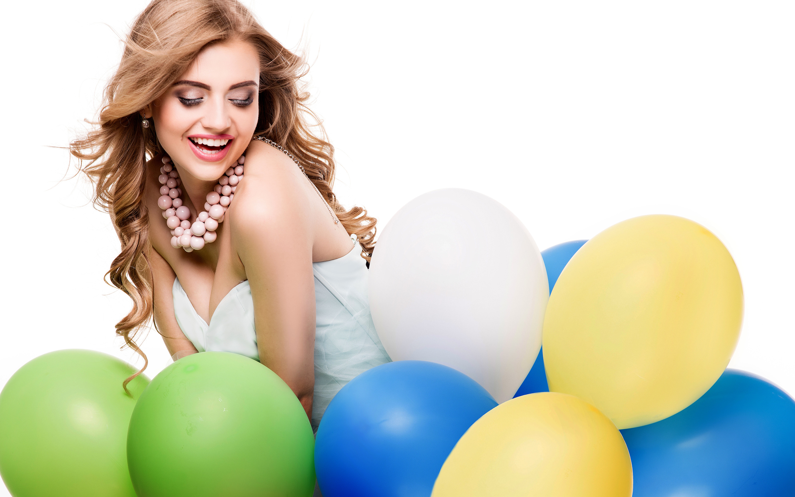 Красивая улыбающаяся девушка с разноцветными шариками на белом фоне
