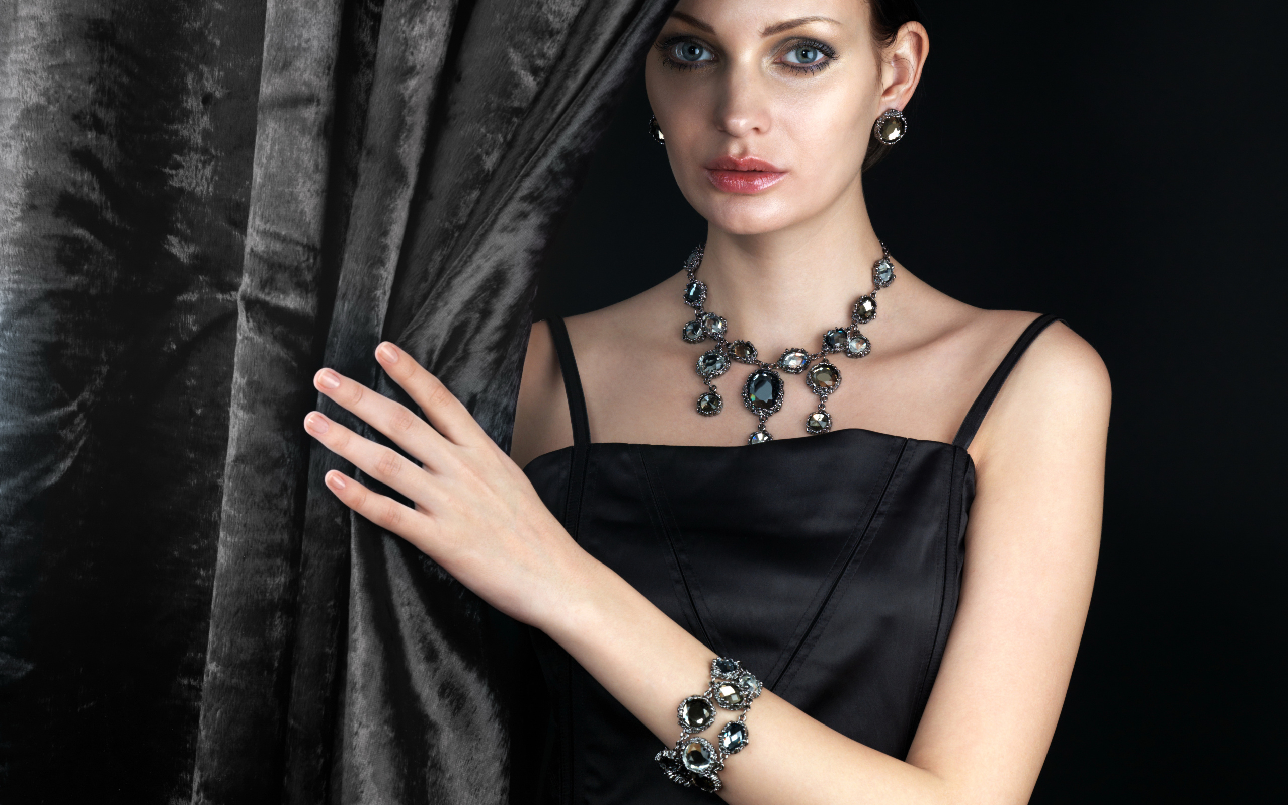 Эффектная девушка в черном платье и дорогих украшениях
