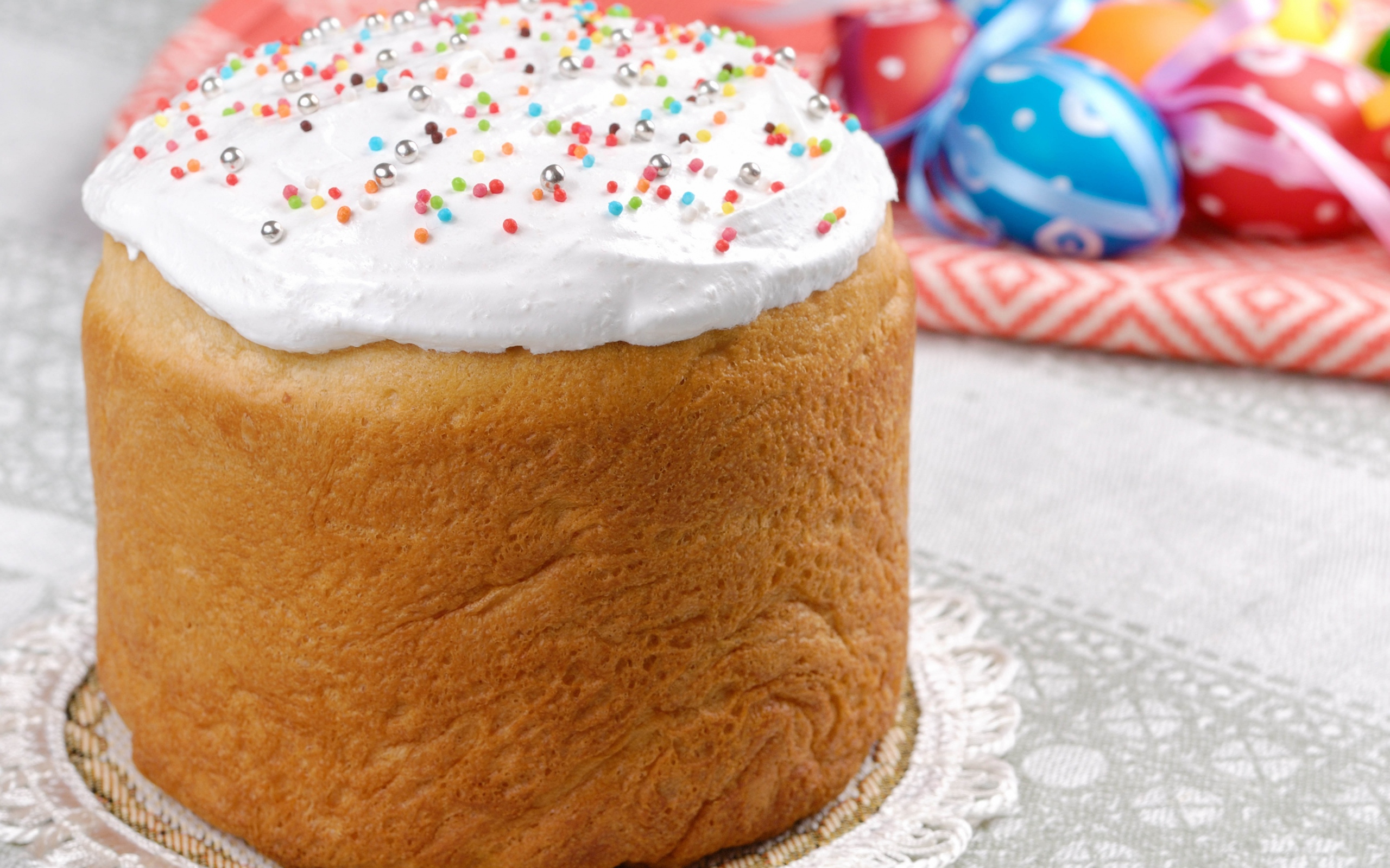 Пасхальный кулич с белой глазурью на столе 