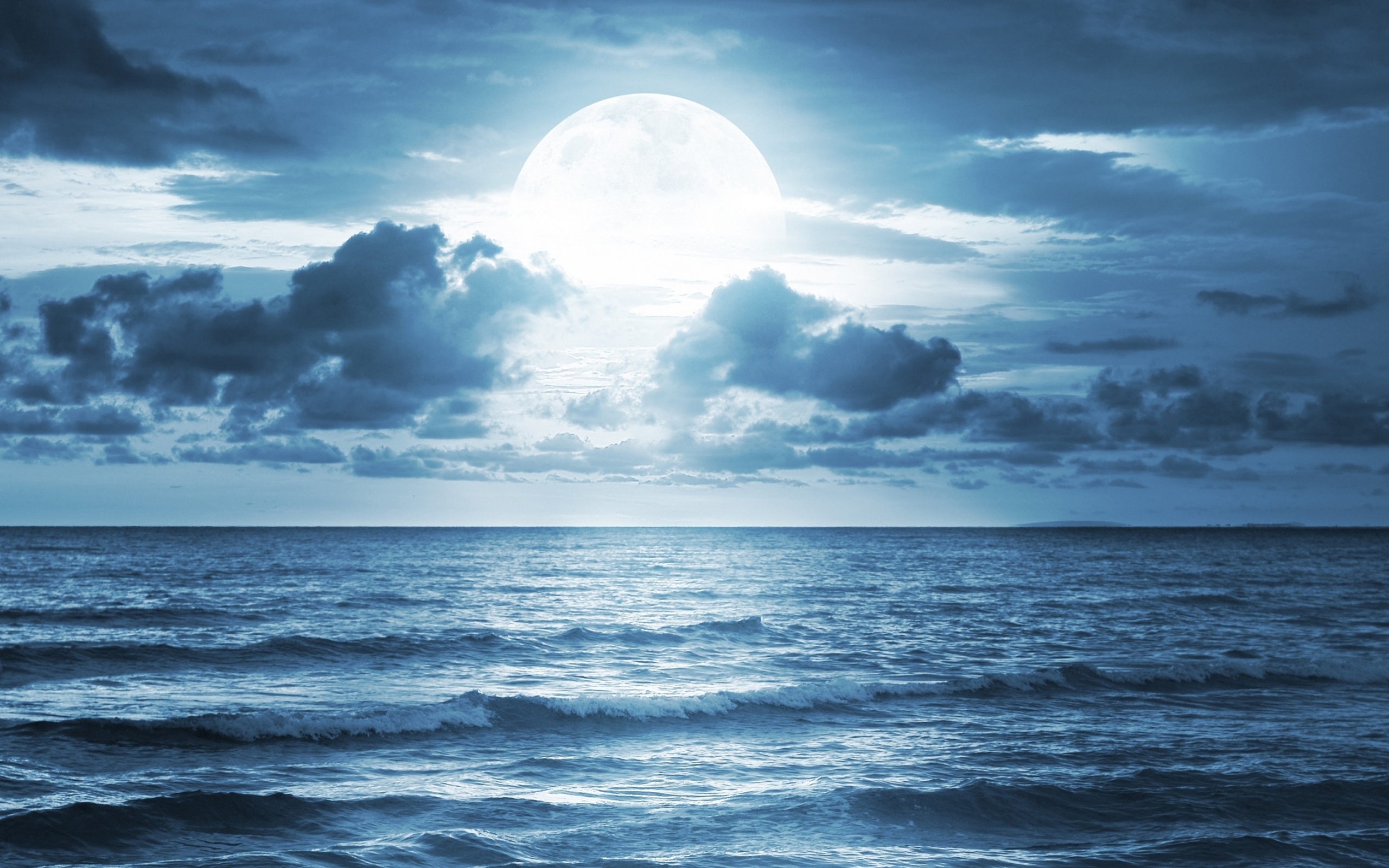 Большая луна в облаках над океаном