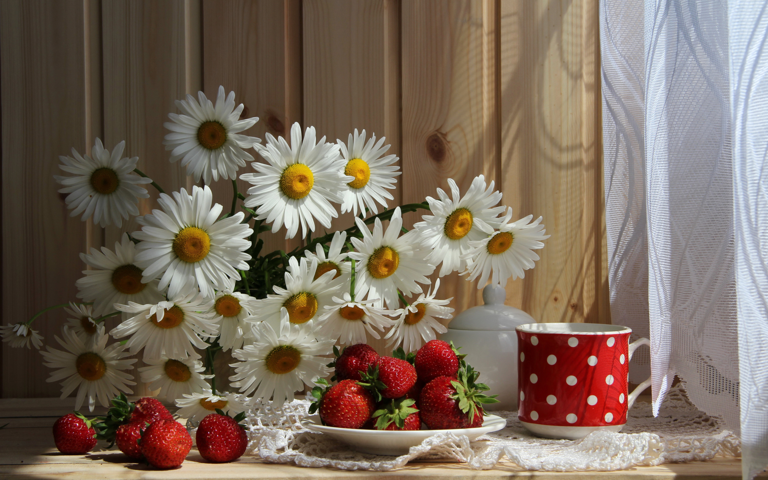 Букет белых ромашек на столе с клубникой