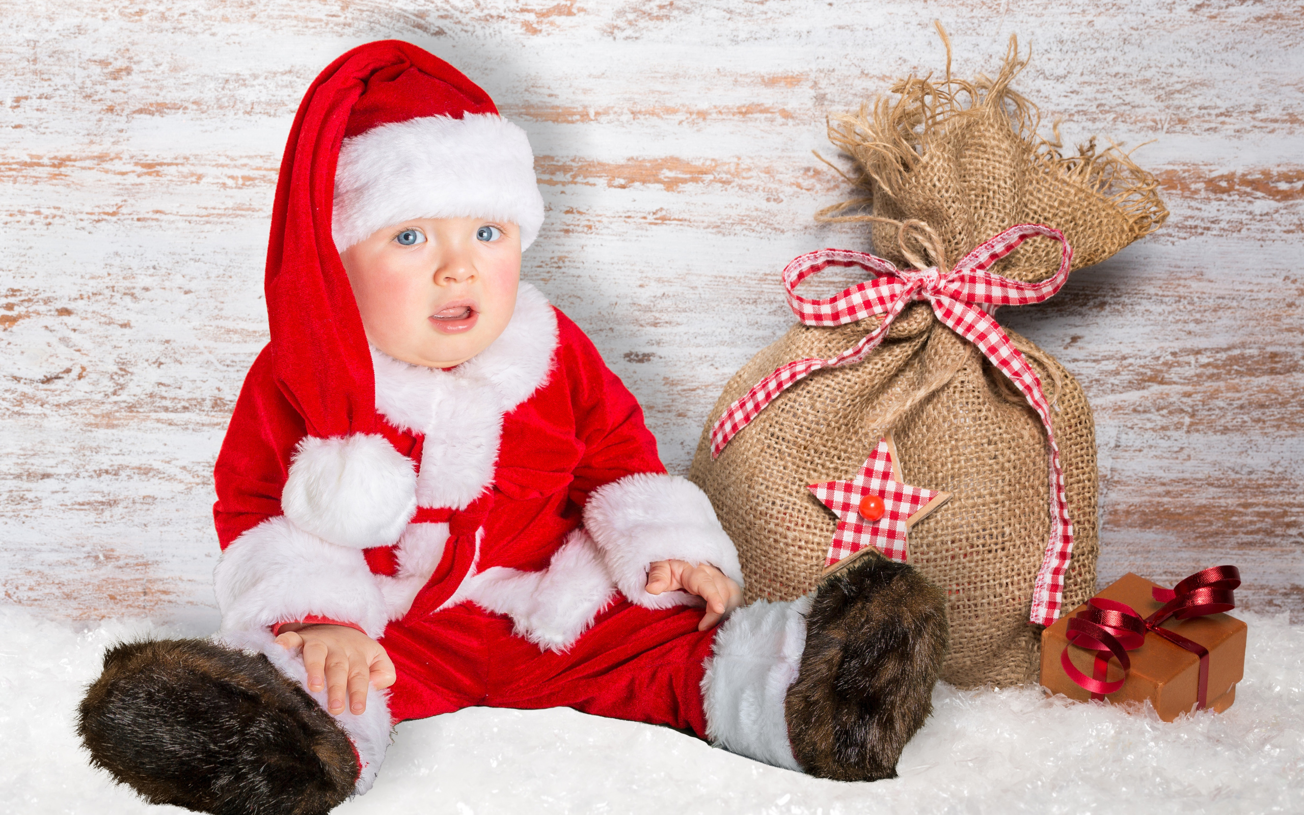 Маленький ребенок в костюме Санты с мешком