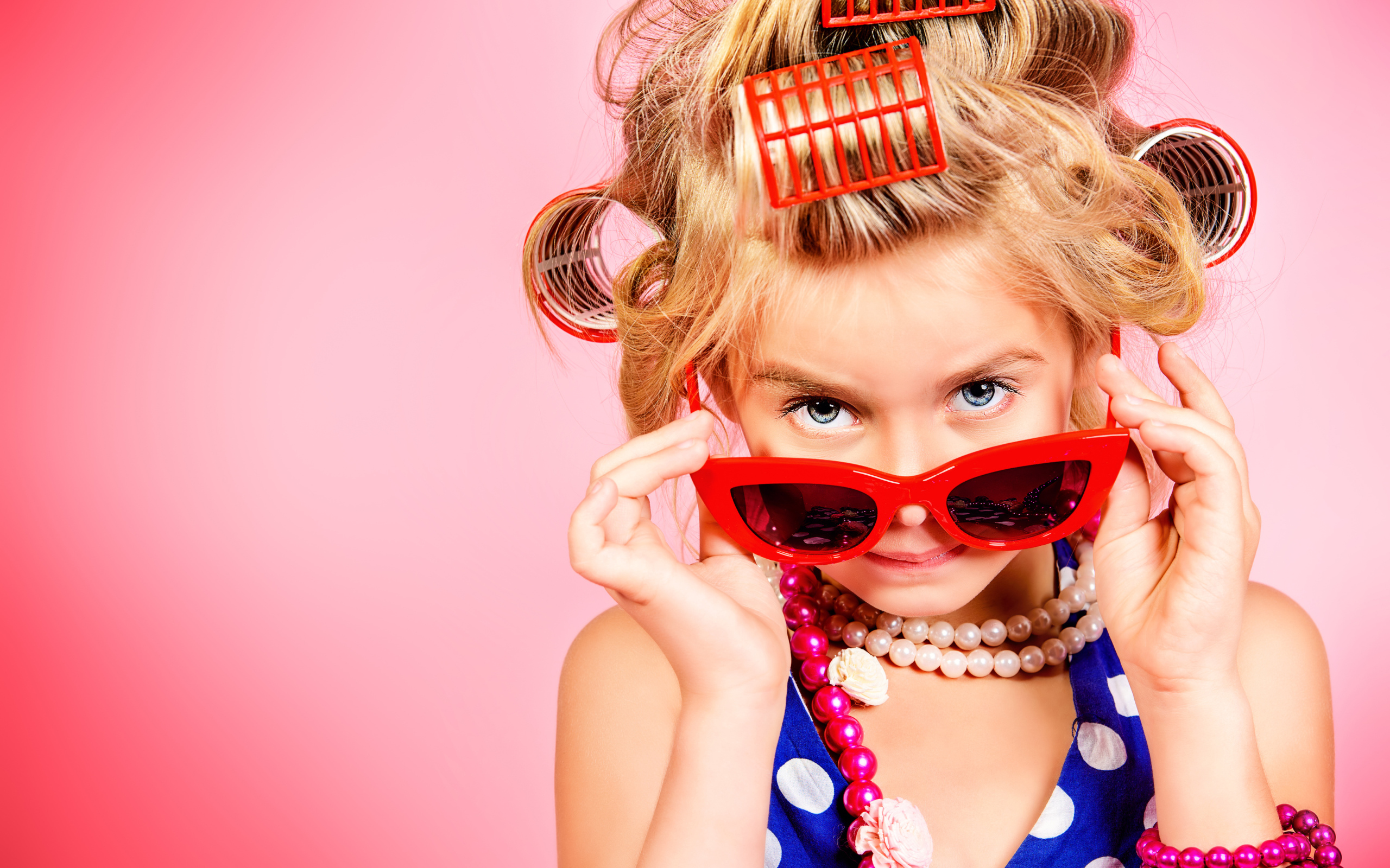 Гламурная девочка в больших красных очках и бигудями на голове