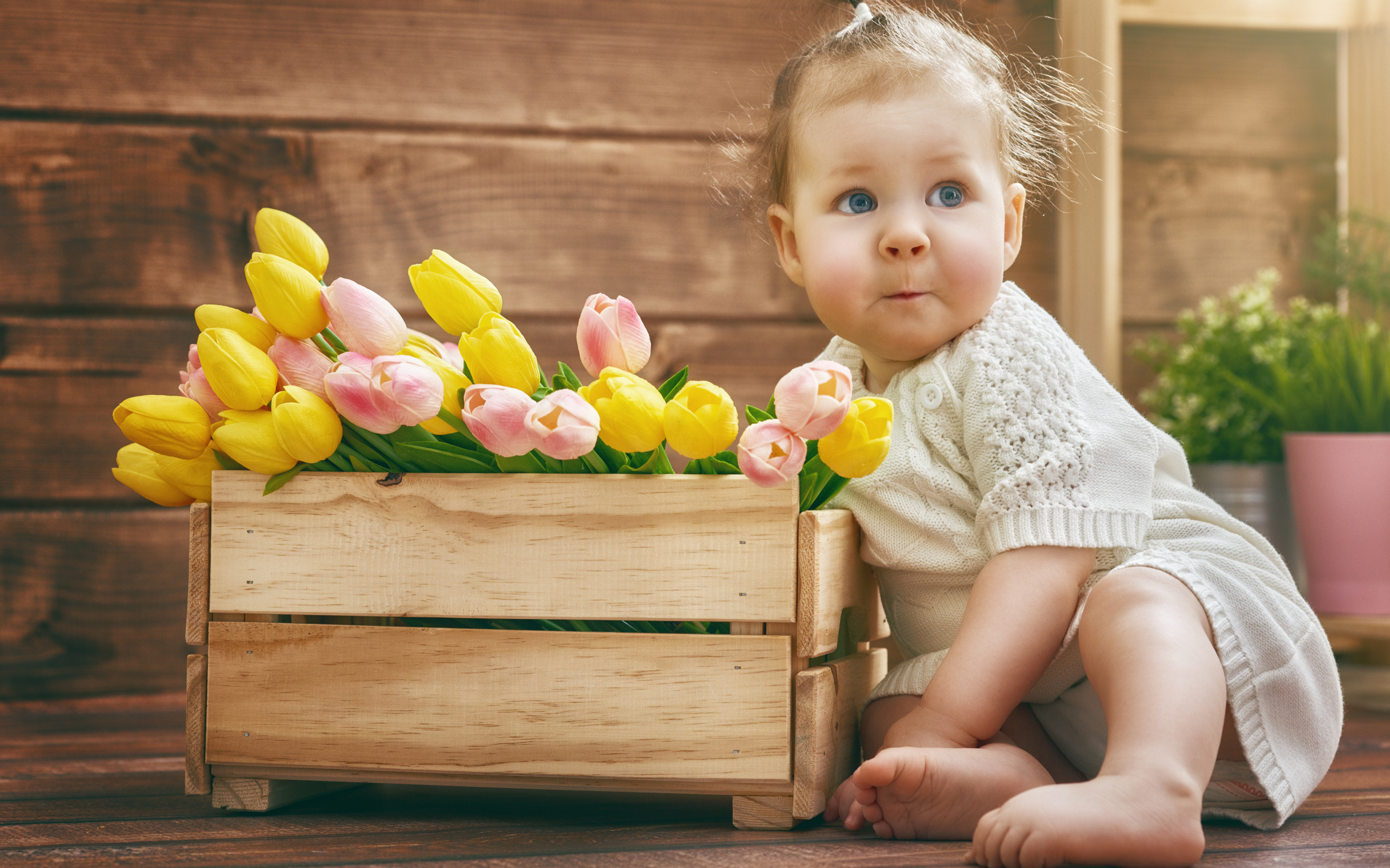 Маленькая забавная девочка с букетом тюльпанов