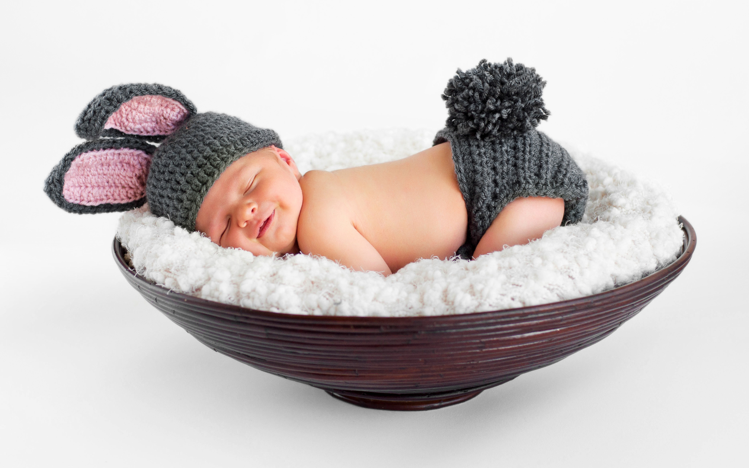 Маленький спящий грудной ребенок в вязаном костюме зайчика