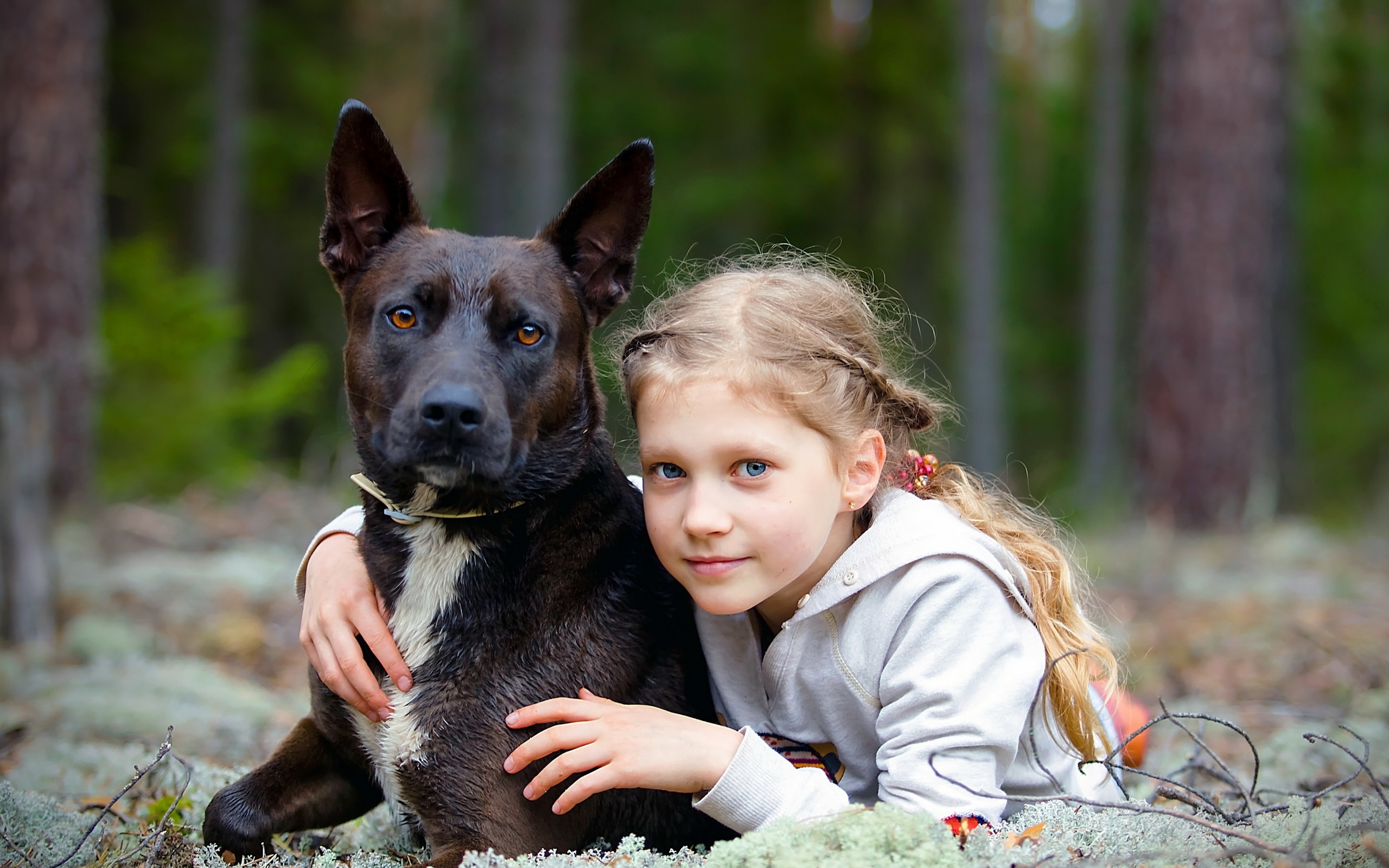 Милая голубоглазая девочка с большой черной собакой