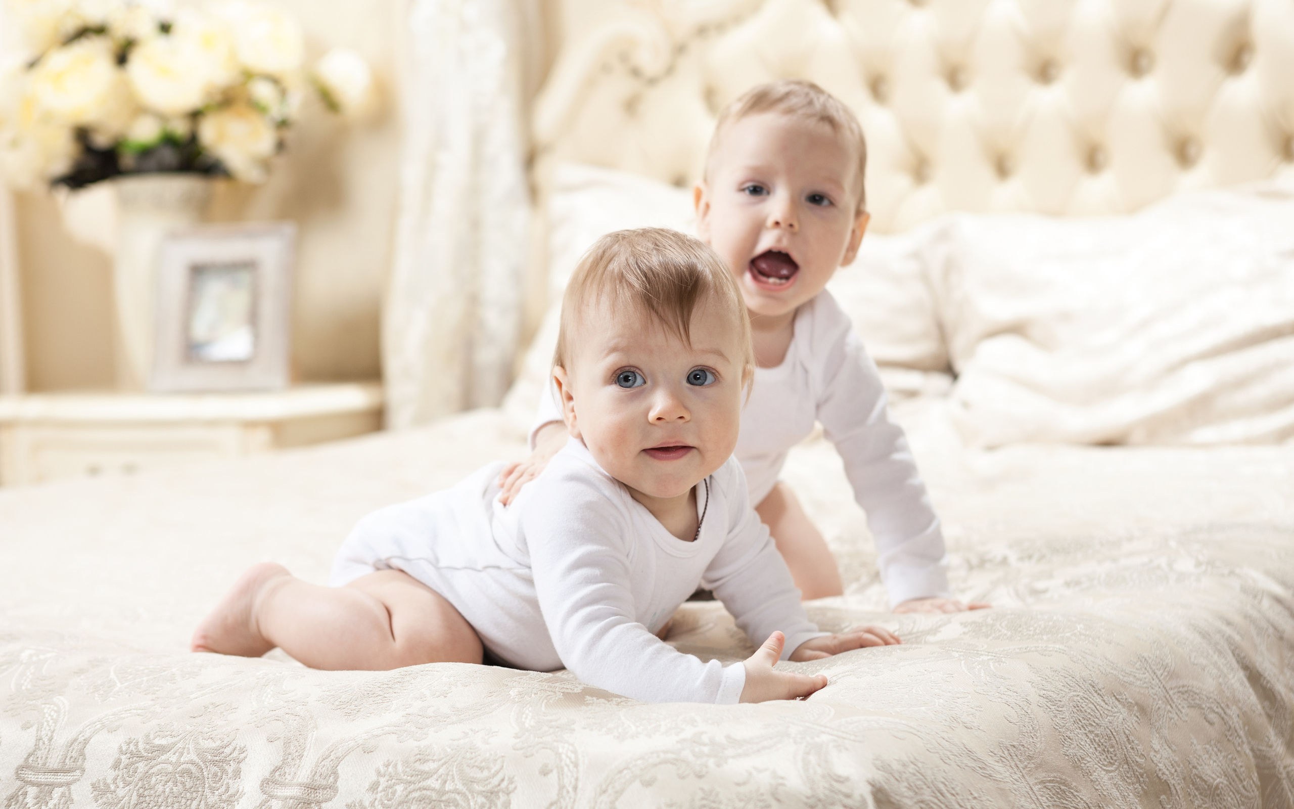 Два забавных младенца лежат на кровати