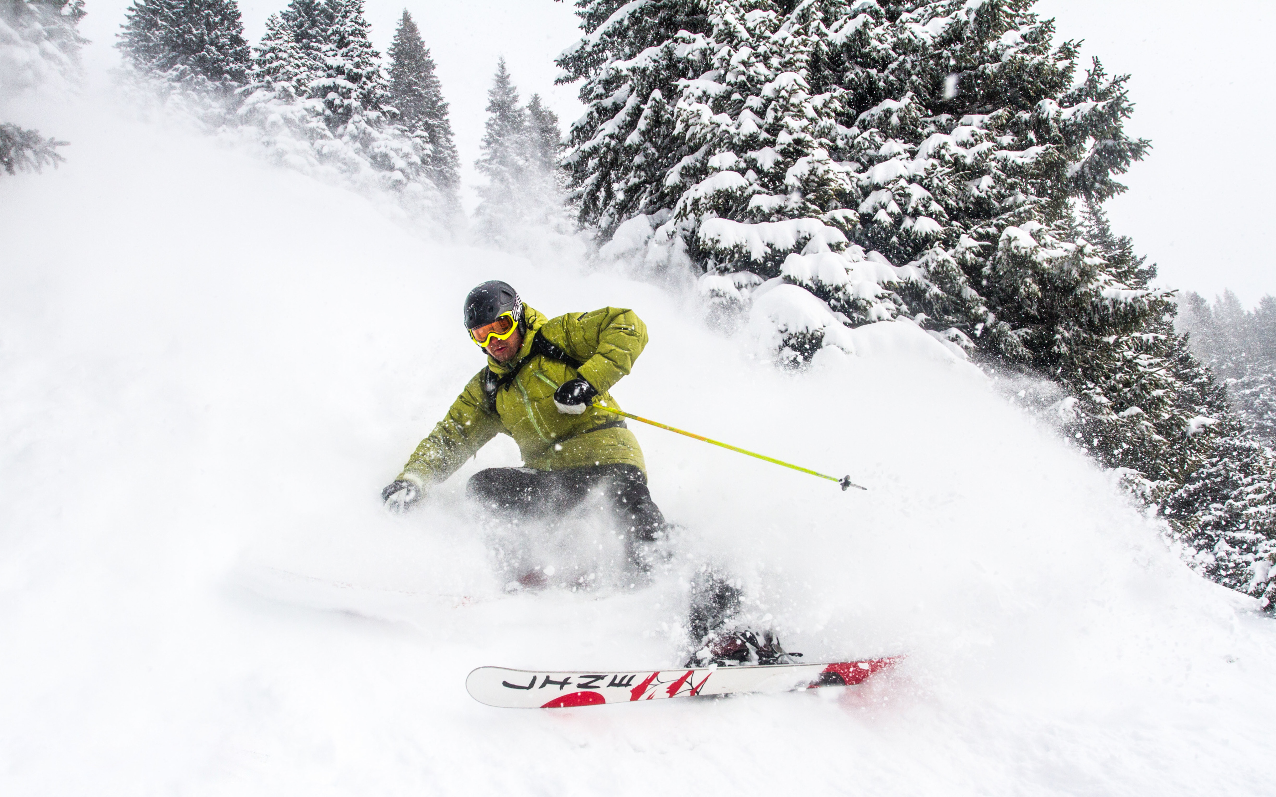 Спортсмен лыжник спускается по заснеженному склону