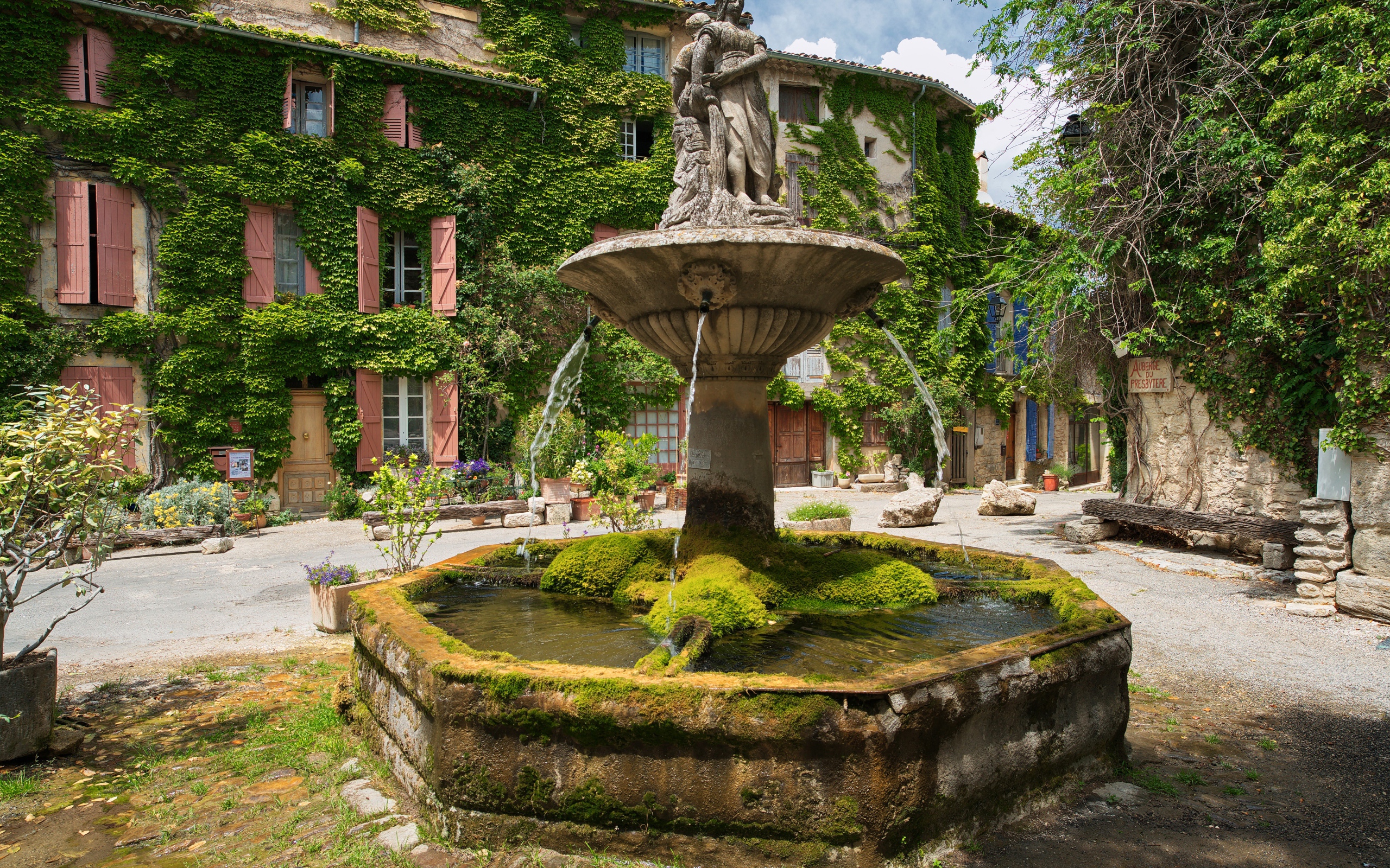 Старинный покрытый мхом фонтан на площади Сеньон, Франция