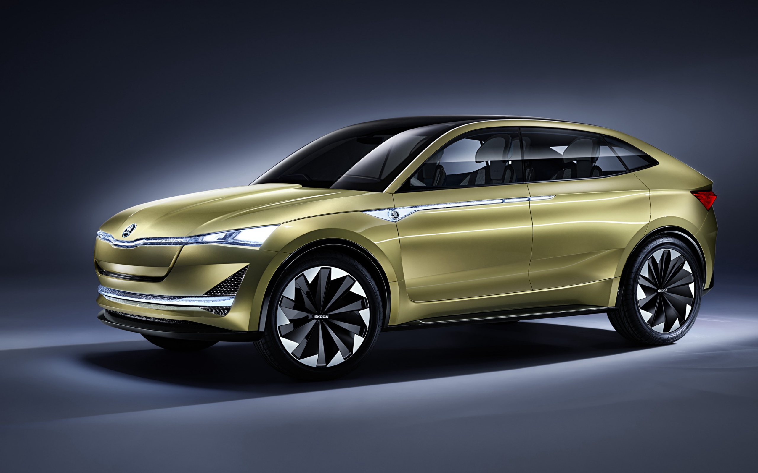 Электромобиль Skoda Vision E цвета золотой металлик на сером фоне