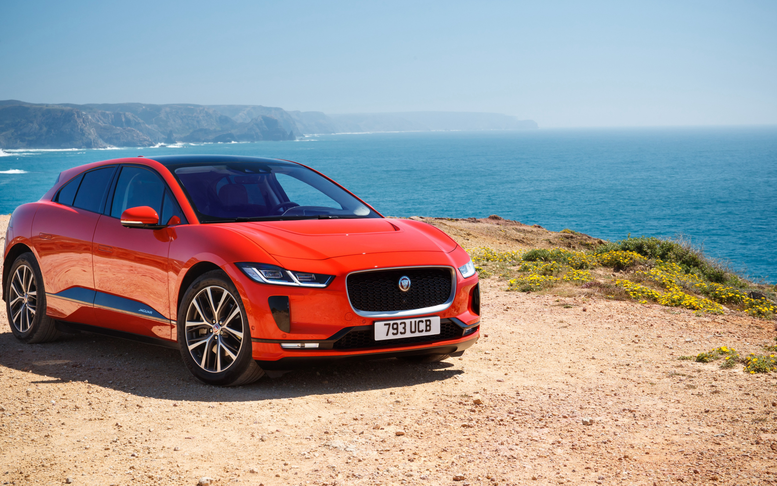 Красный Jaguar I-Pace EV400 AWD HSE First Edition 2018 года на фоне океана 