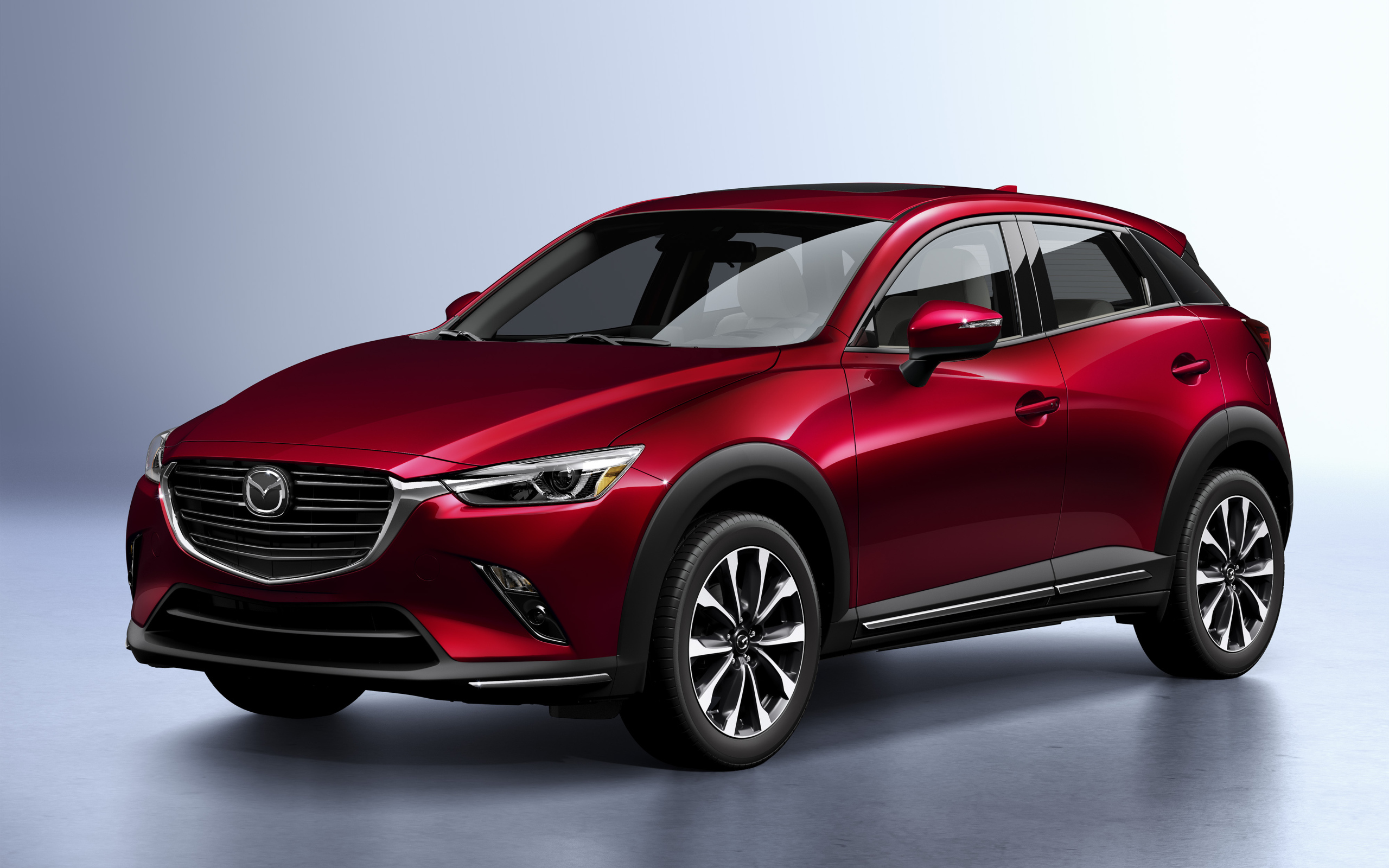 Бордовый внедорожник Mazda CX-3, 2019 года на сером фоне