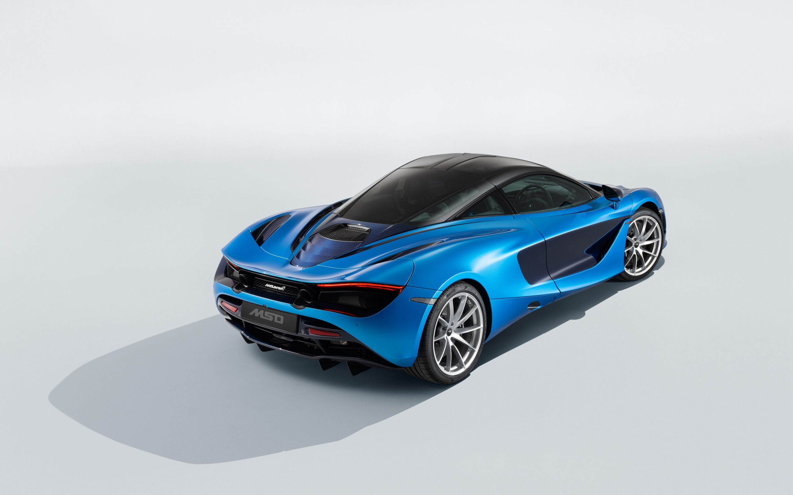 Голубой быстрый автомобиль McLaren 720S, 2018 года вид сзади