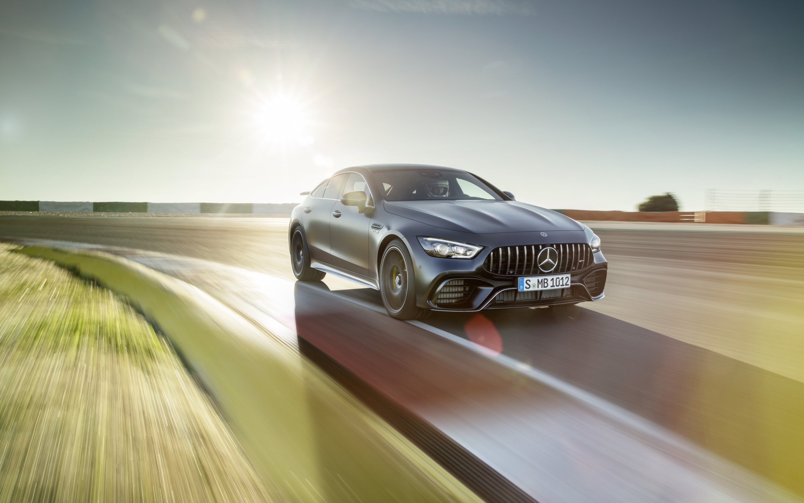 Серебристый автомобиль Mercedes-AMG GT4, 2018 года на скорости 
