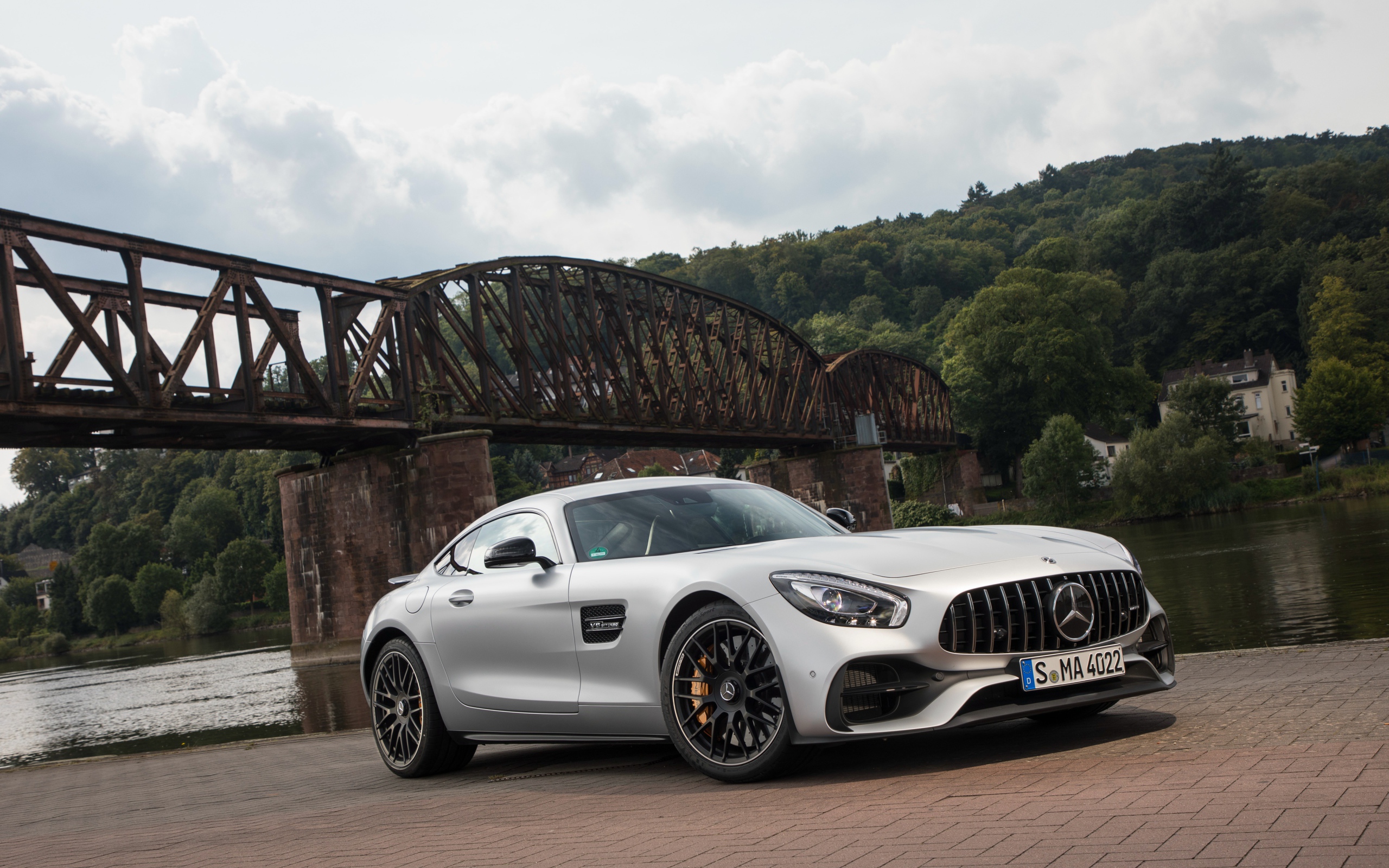Серебристый автомобиль Mercedes-AMG GT на фоне моста