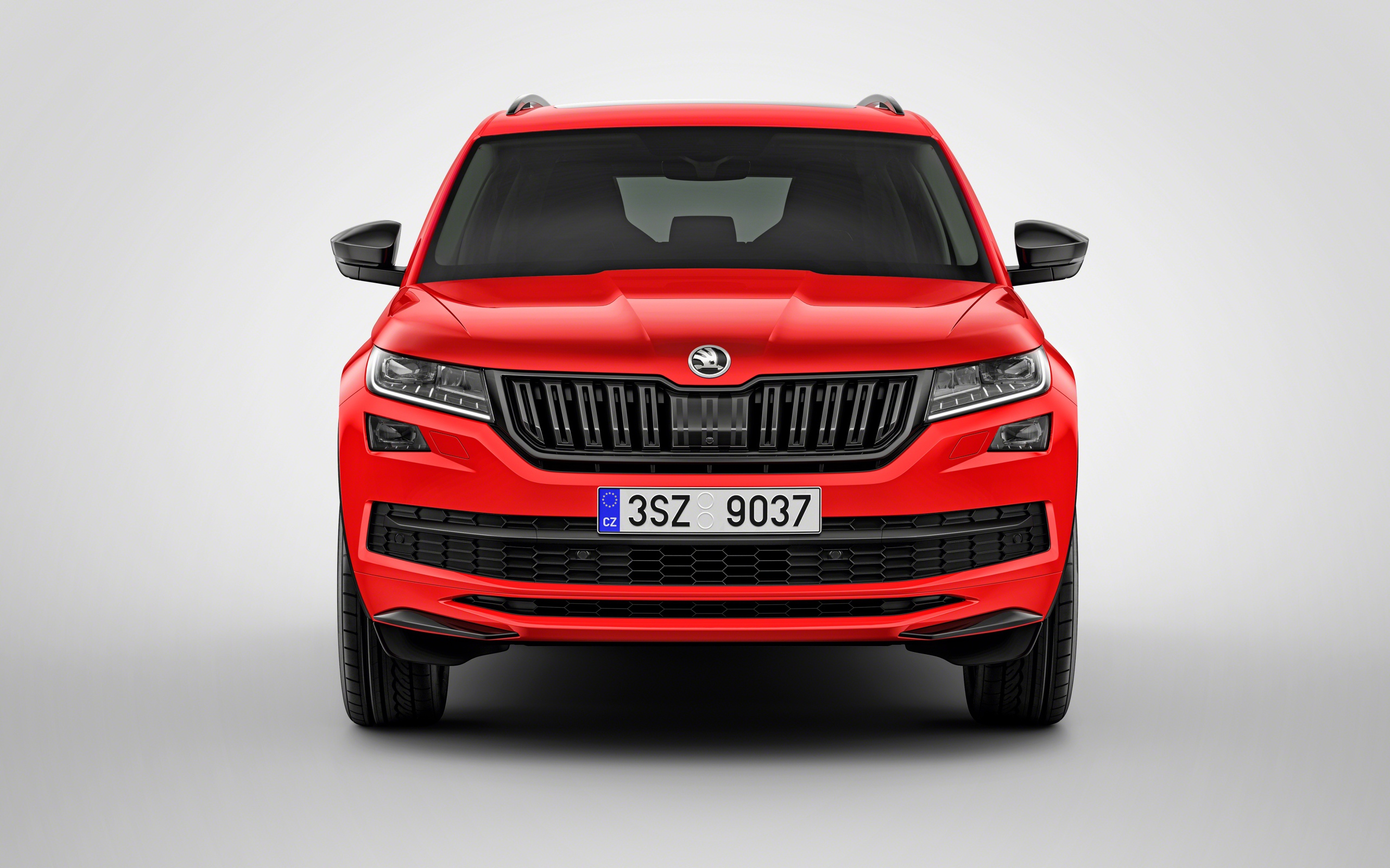 Красный автомобиль Skoda Kodiaq на сером фоне