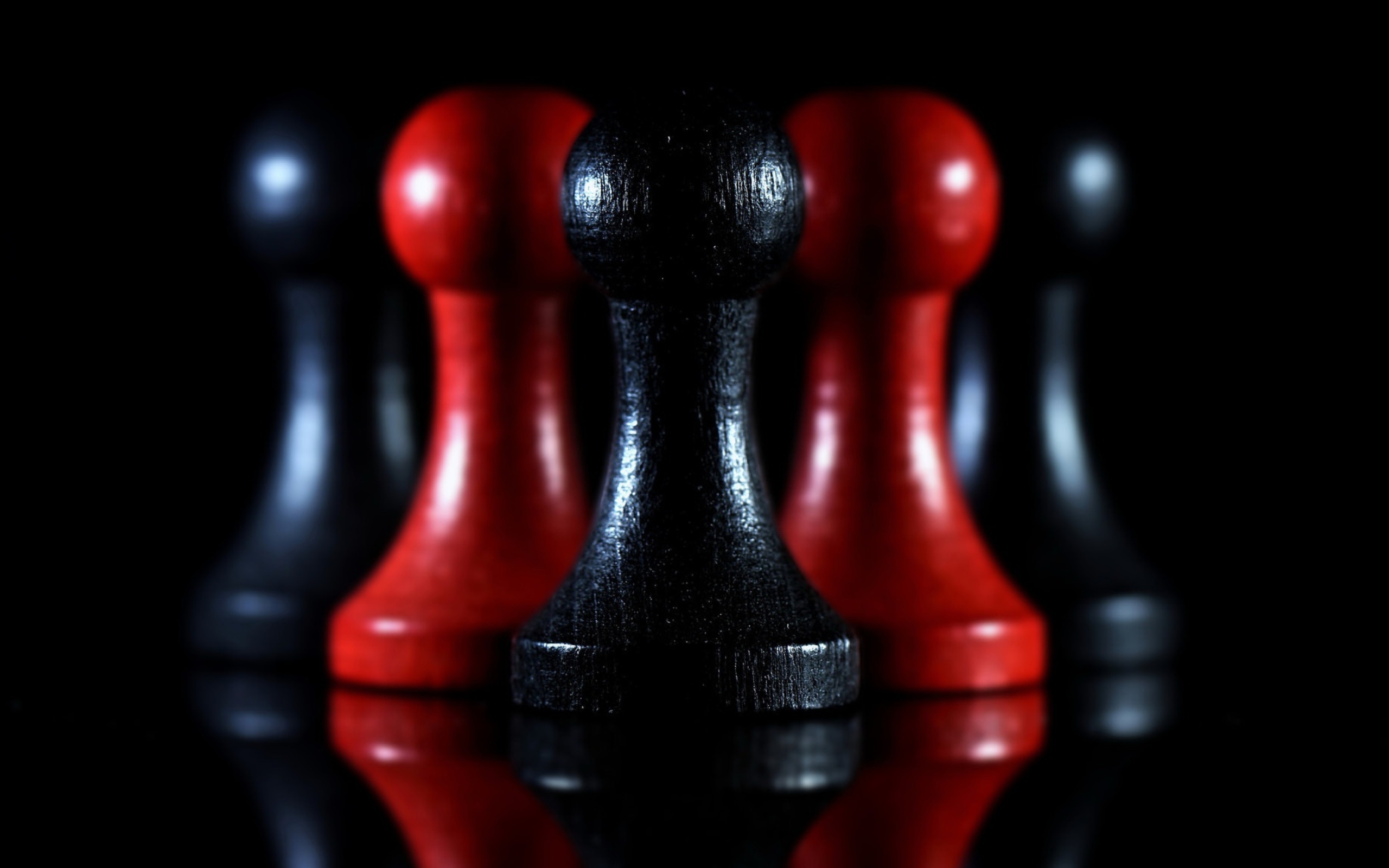 Красные и черные шахматные фигуры на черном фоне