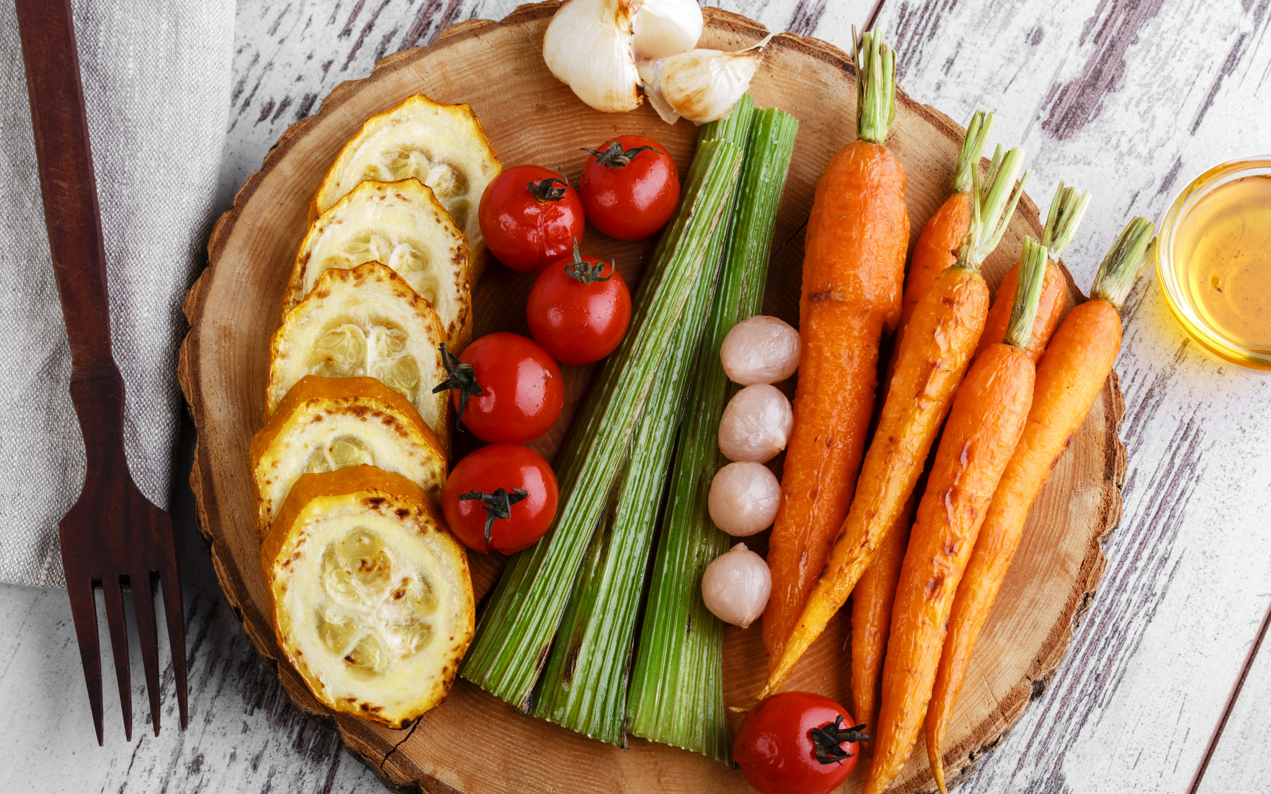 Печеные кабачки, помидоры, морковь, сельдерей и чеснок на разделочной доске