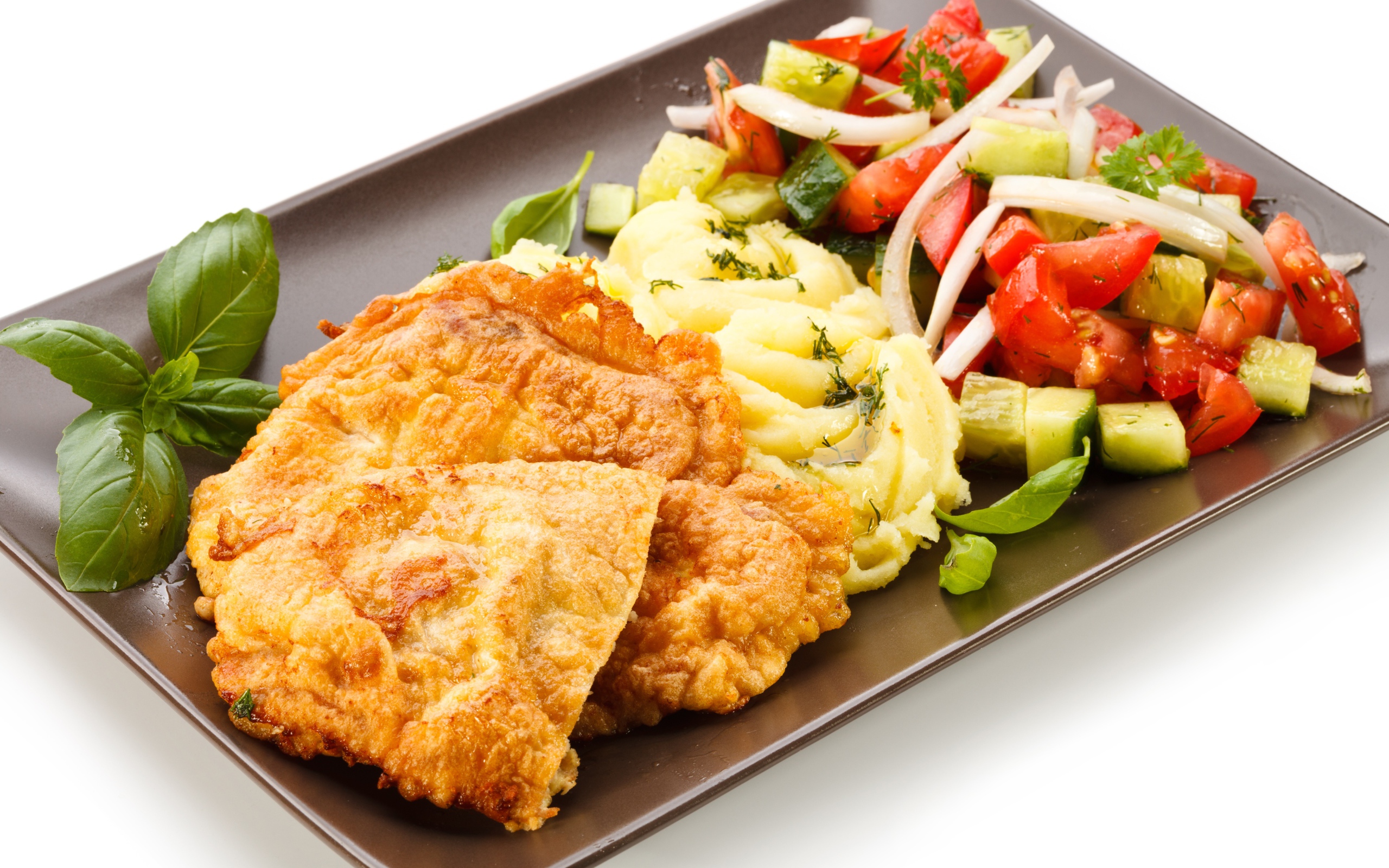 Отбивные с пюре и овощным салатом на тарелке