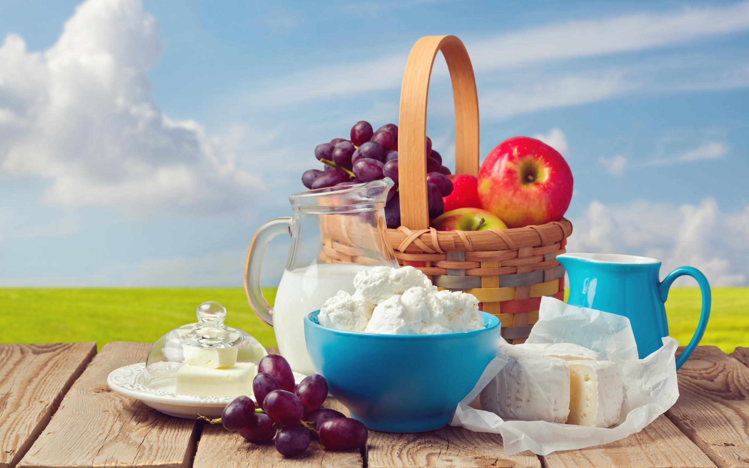 Творог с молоком на столе с виноградом и яблоками 
