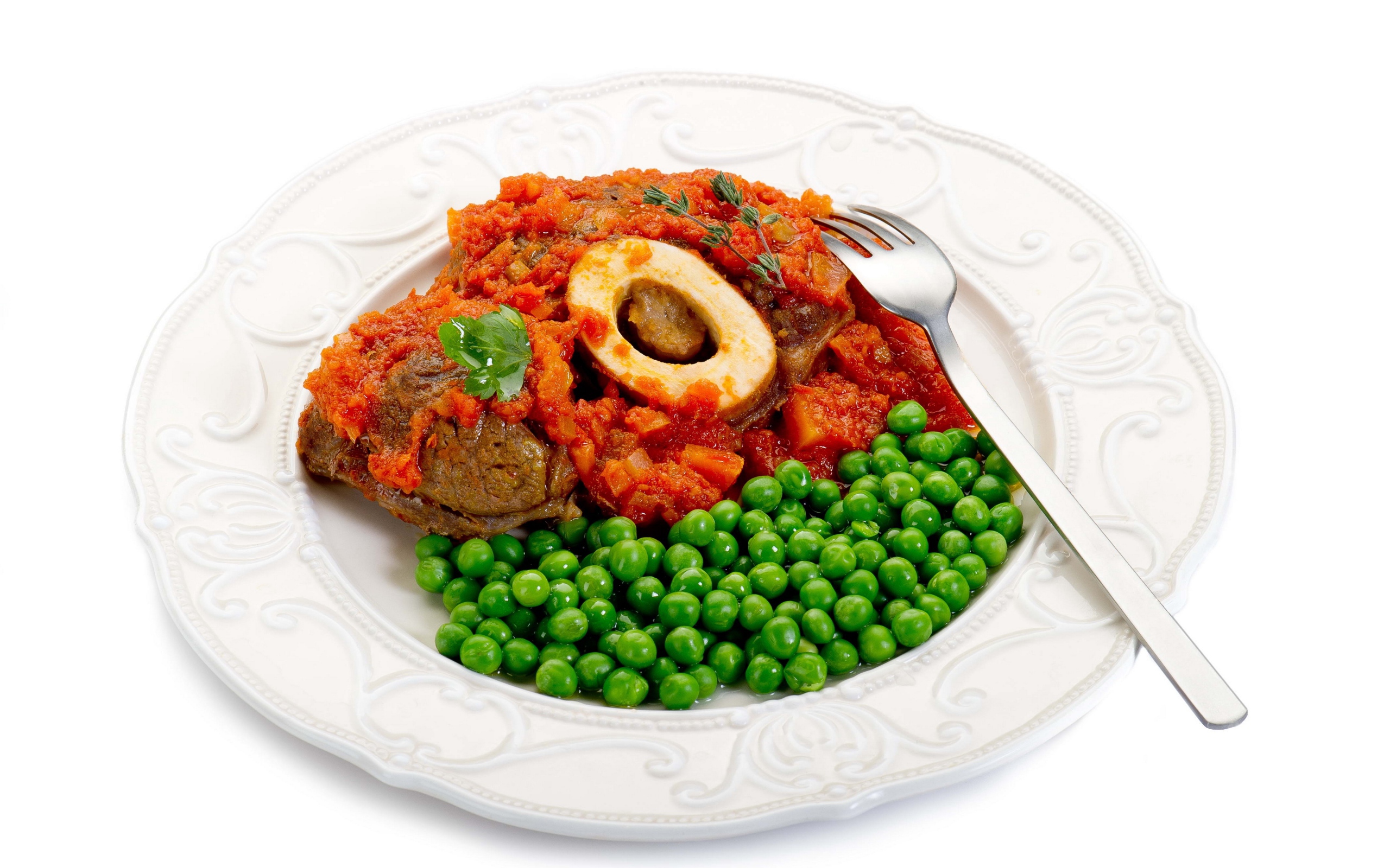 Зеленый горошек на белой тарелке с мясом