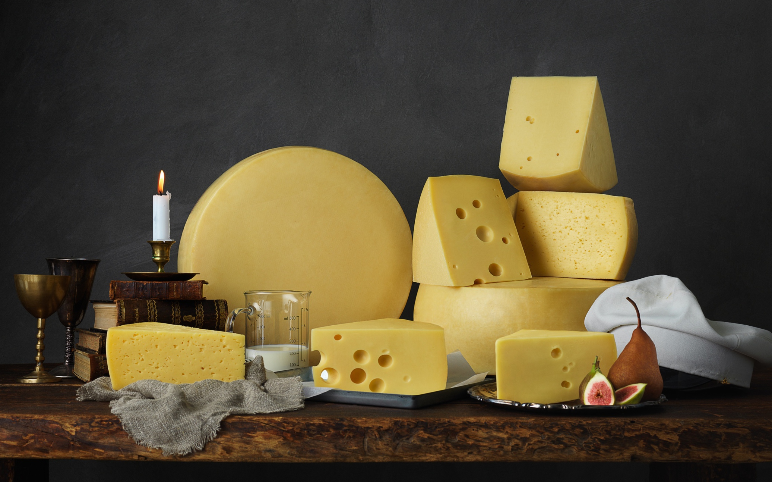 Твердый сыр на столе с книгами 