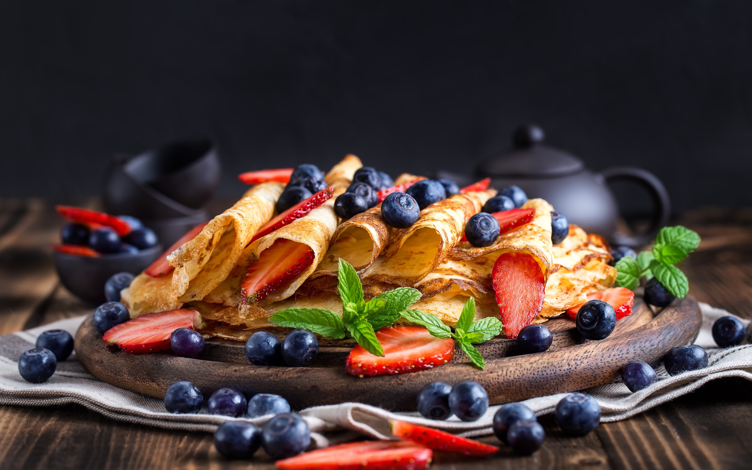 Блинчики с ягодами черники и клубники на столе