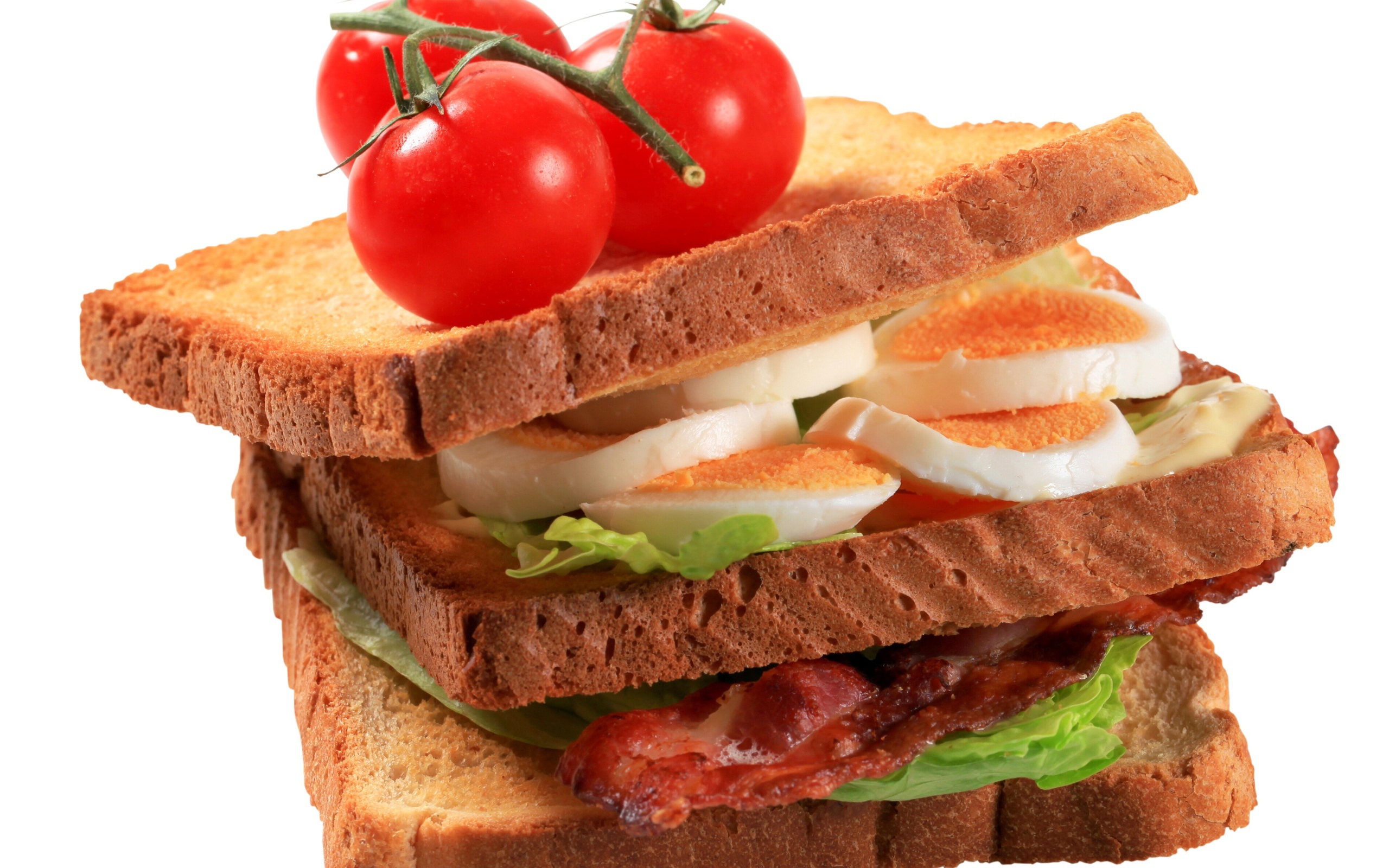 Сэндвич с яйцами, беконом и помидорами на белом фоне