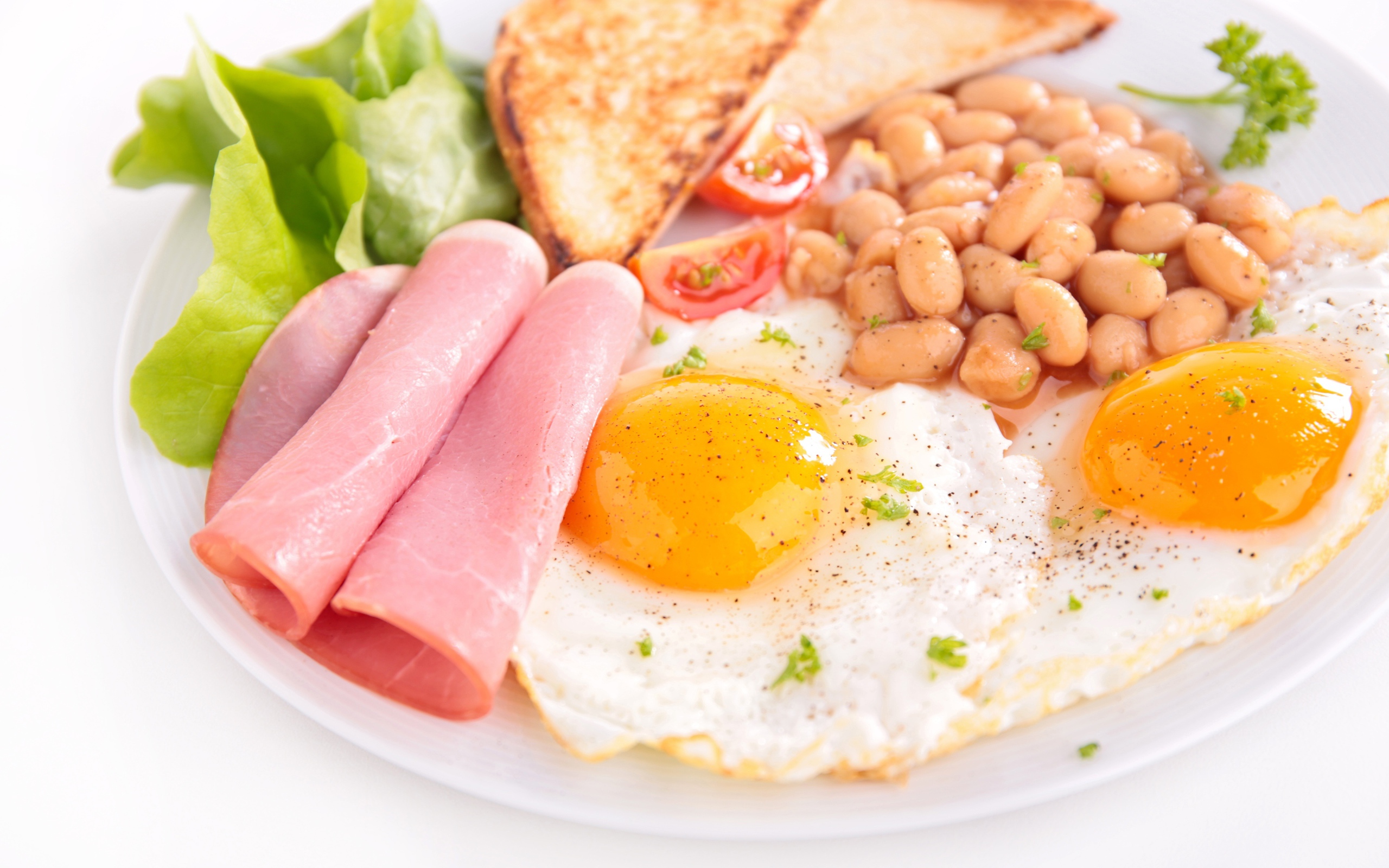 Яичница с беконом, гренками, фасолью и листьями салата на завтрак