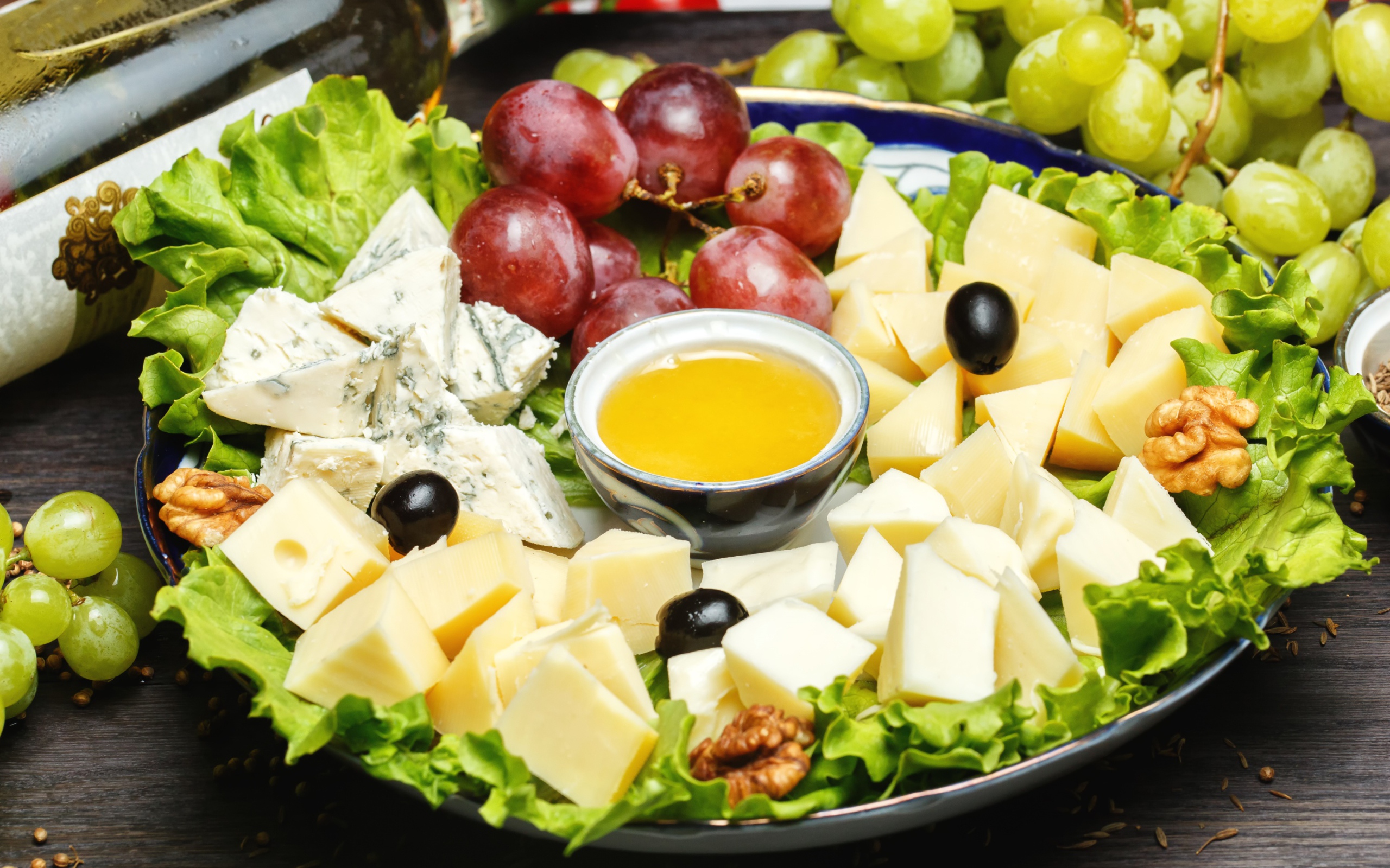 Нарезанный сыр на тарелке в виноградом 