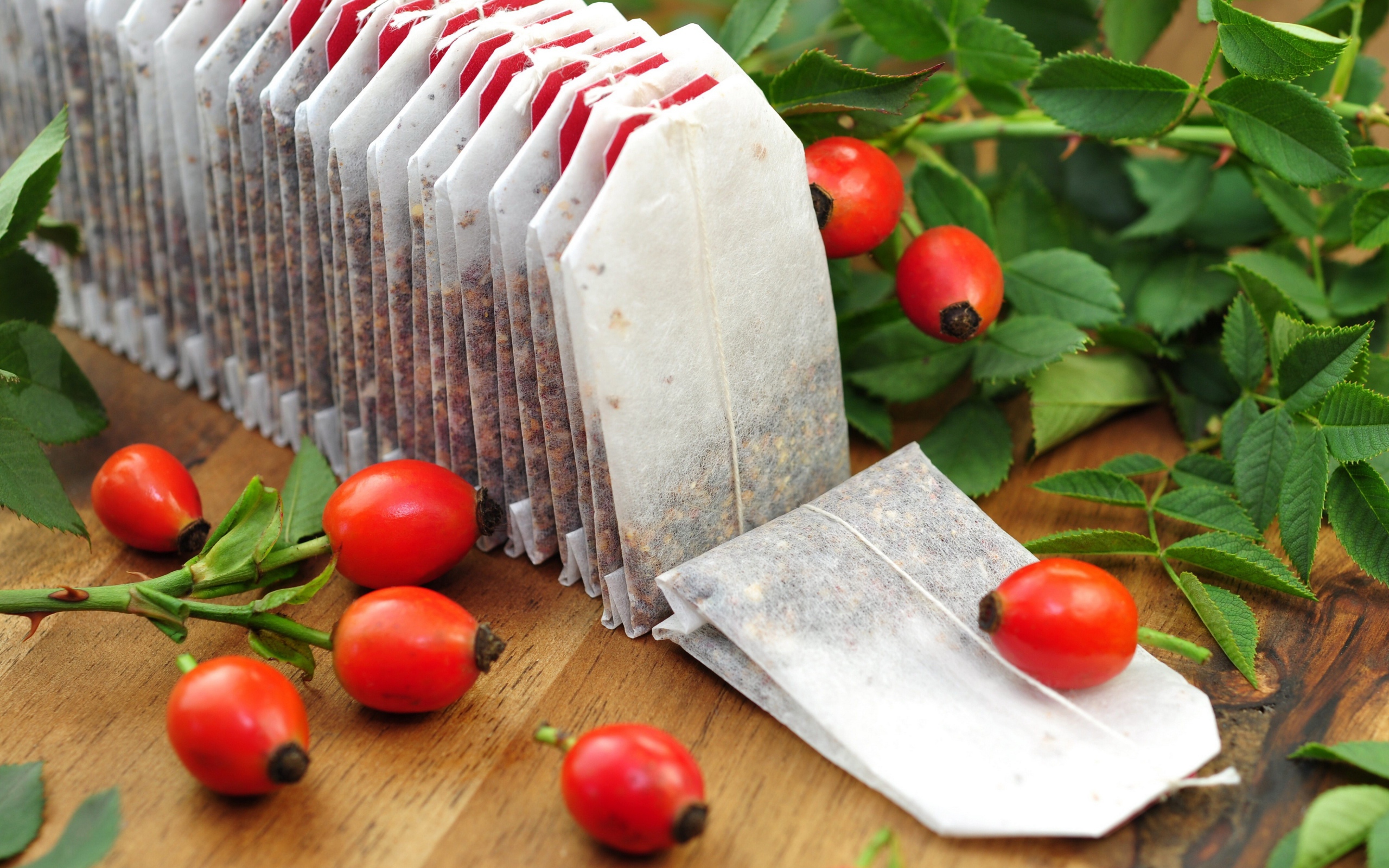 Tea bags on the table with wild rose berries