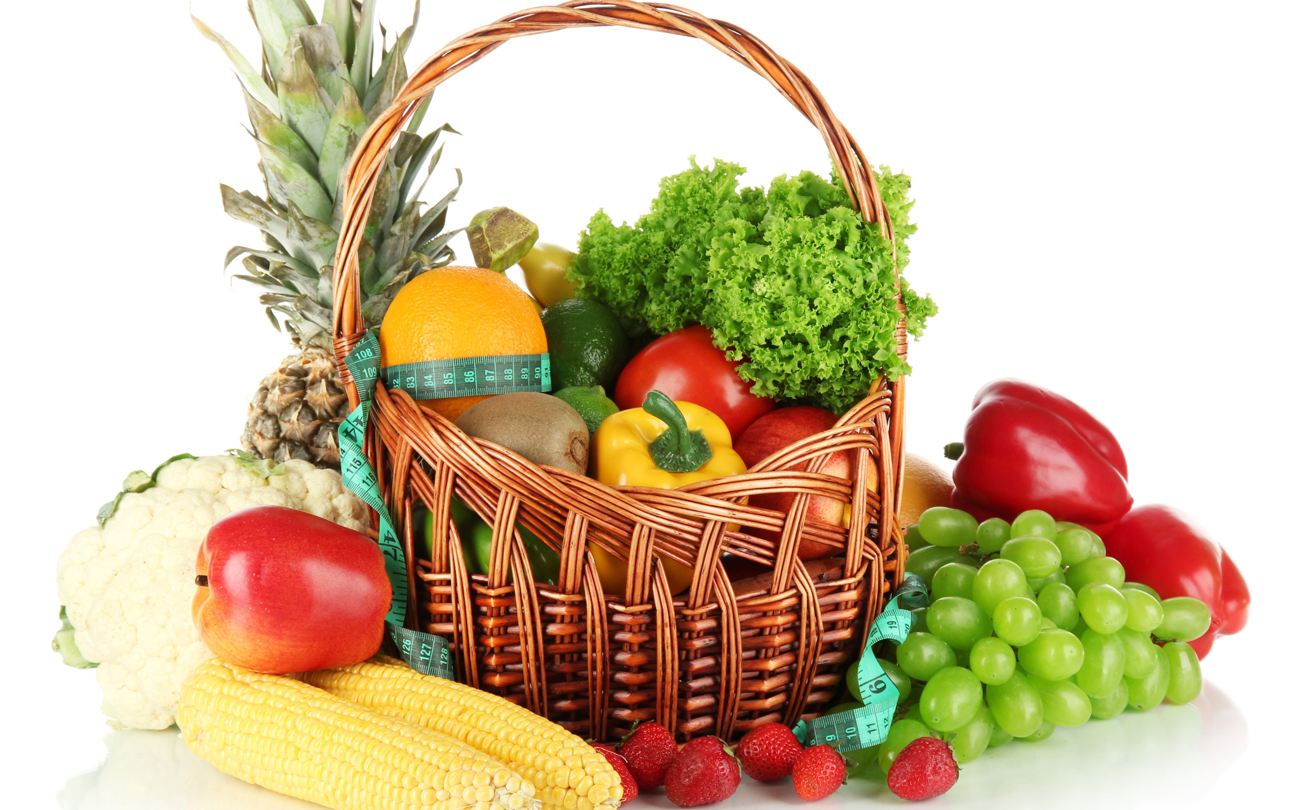 Корзина свежих овощей и фруктов на белом фоне