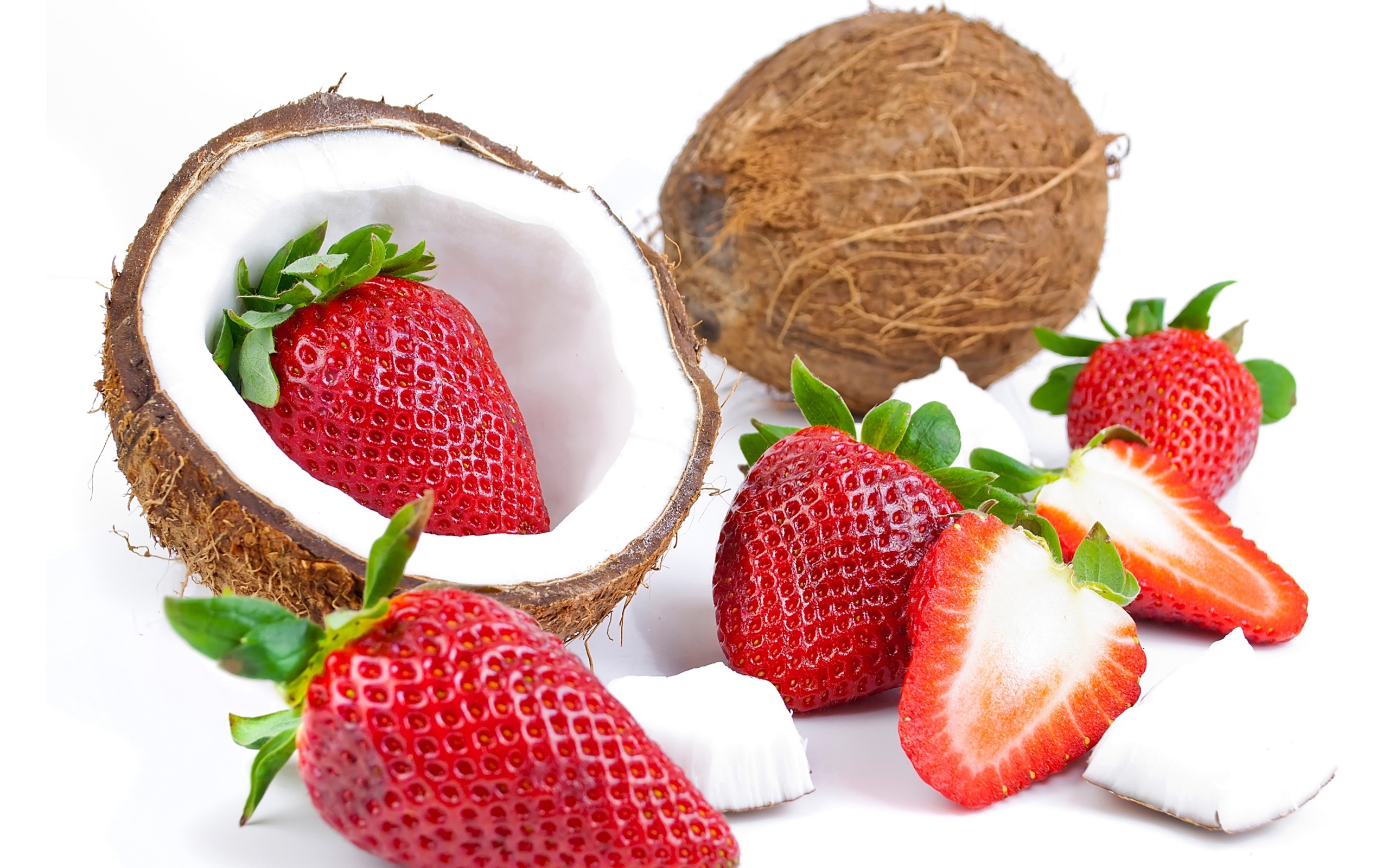 Кокосы со свежей клубникой на белом фоне