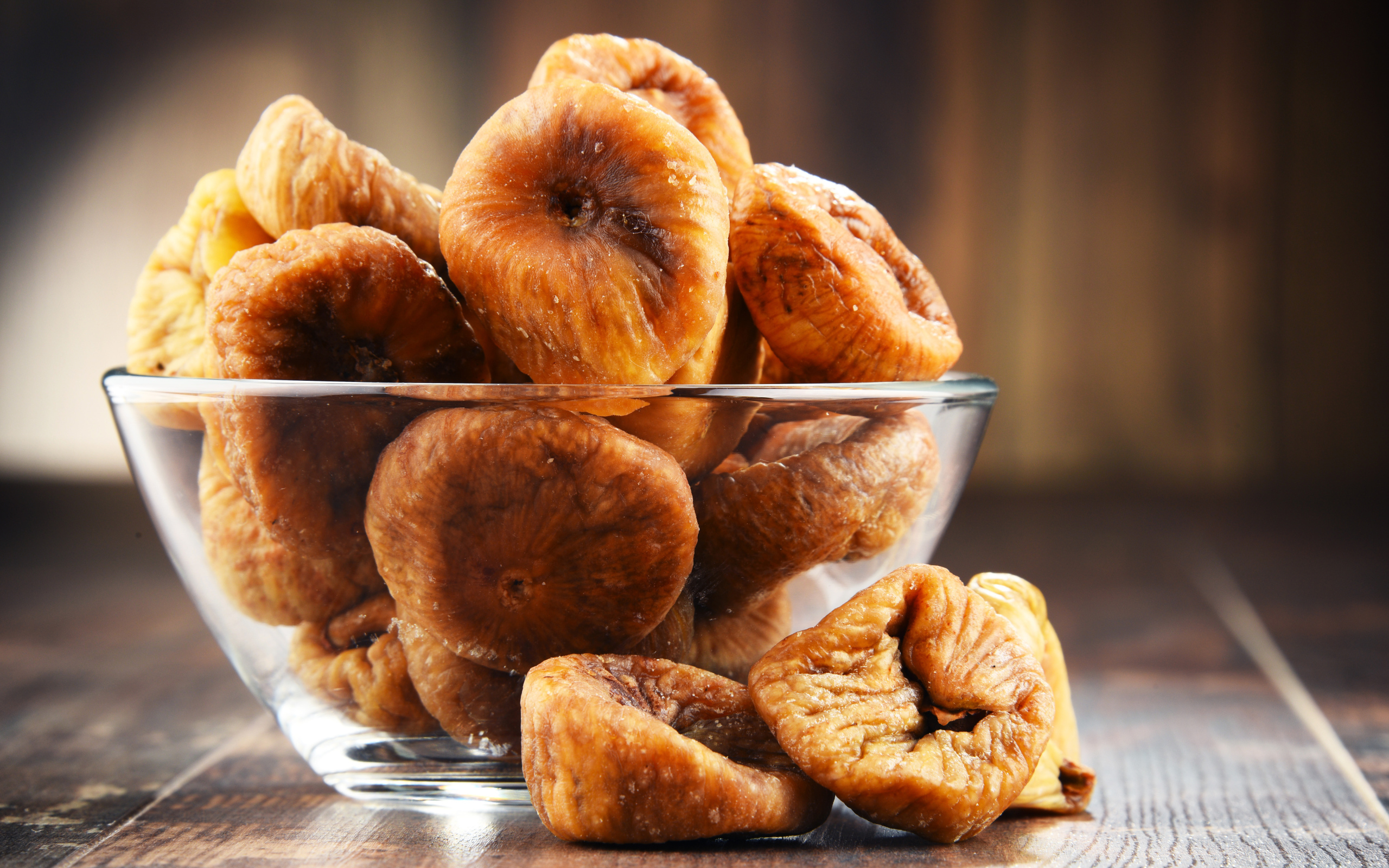 Инжир в стеклянной вазе на столе 