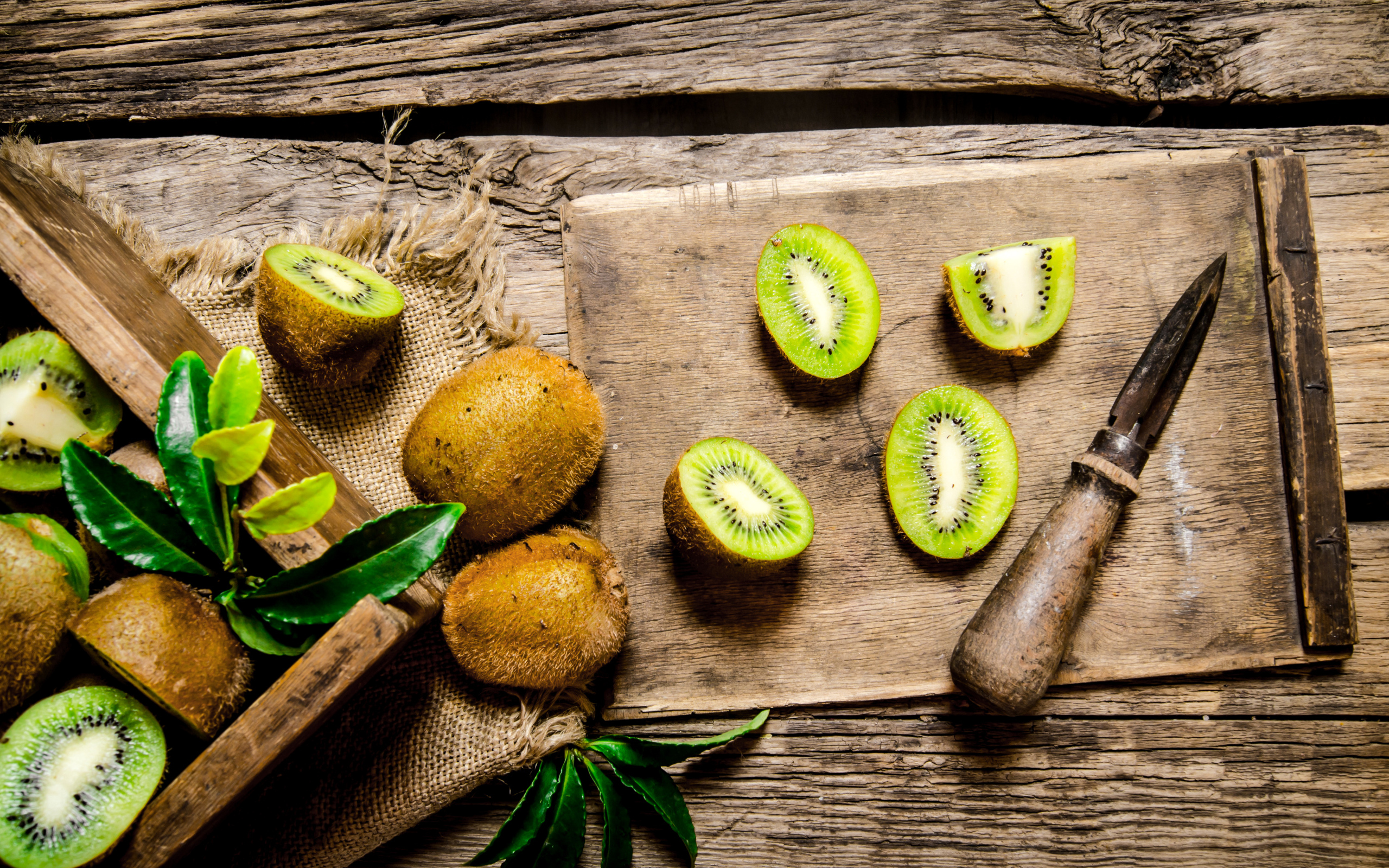 Нарезанное киви на разделочной доске с ножом