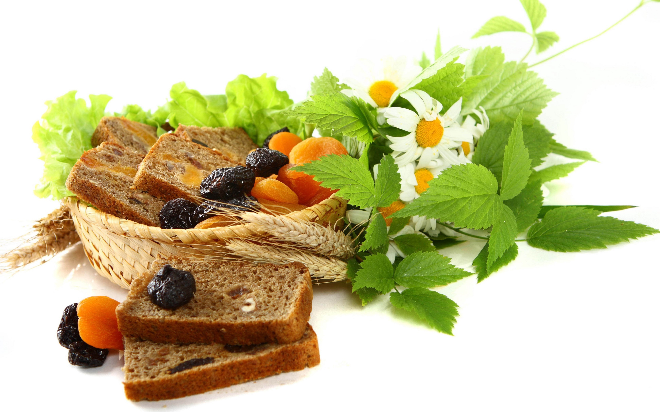 Сухофрукты с хлебом и цветами ромашки на белом фоне