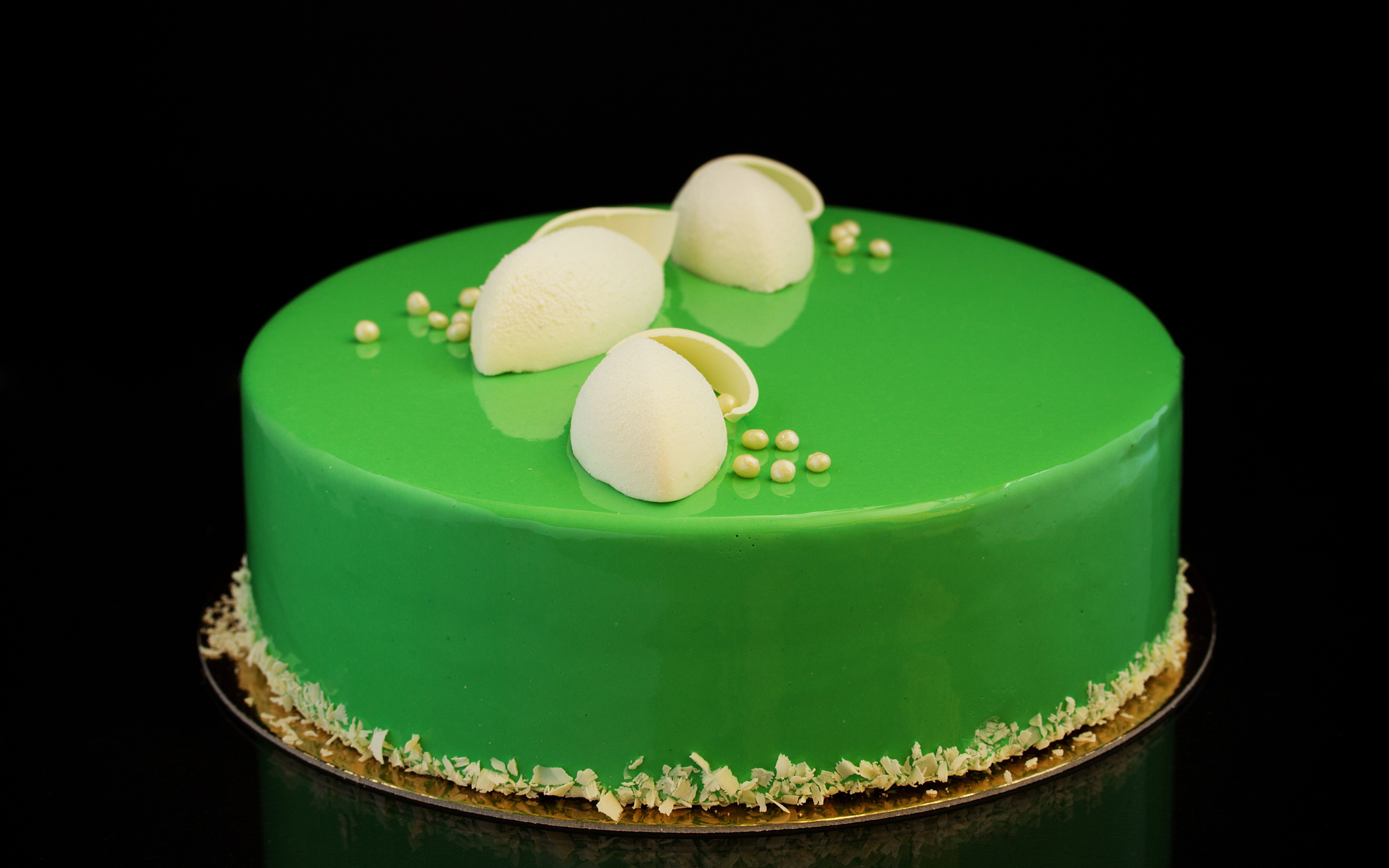 Зеленый глянцевый торт отражается в черной поверхности 