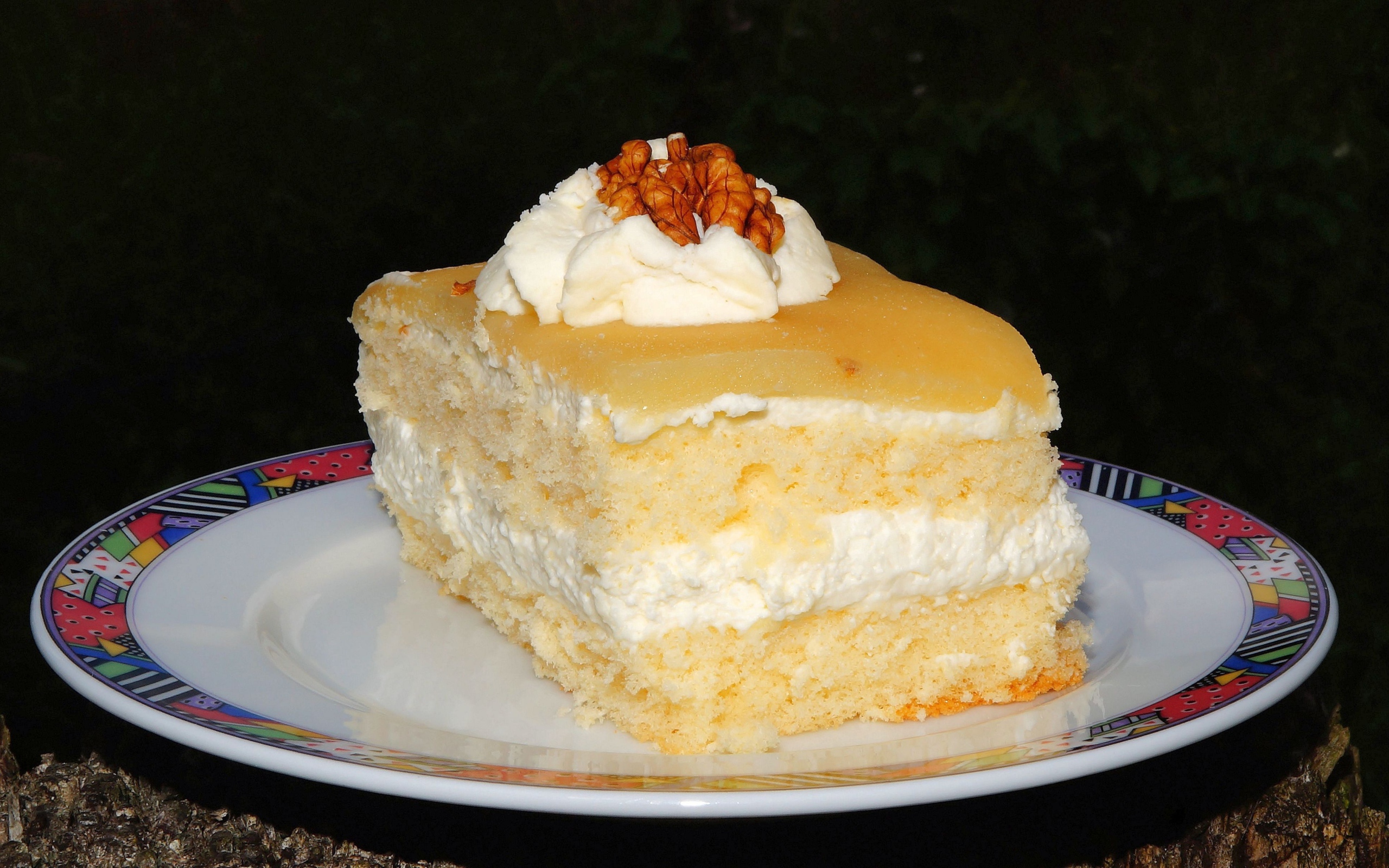 Кусок торта со сливочным кремом и грецкими орехами