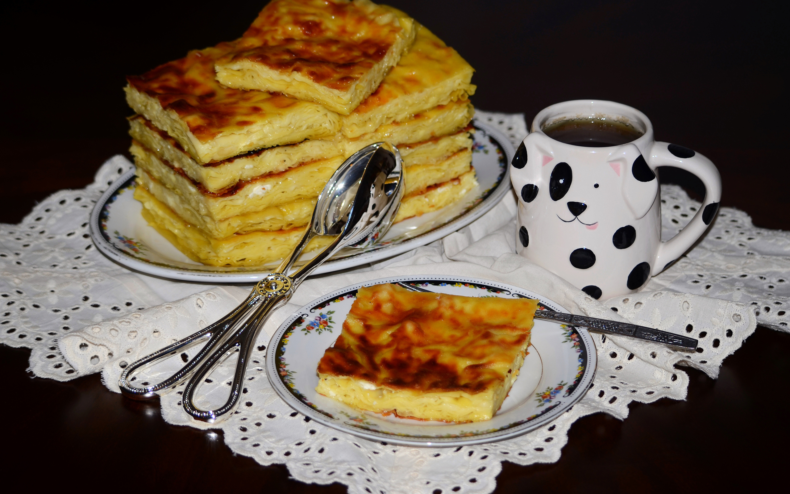 Аппетитный сладкий пирог с чашкой чая на столе