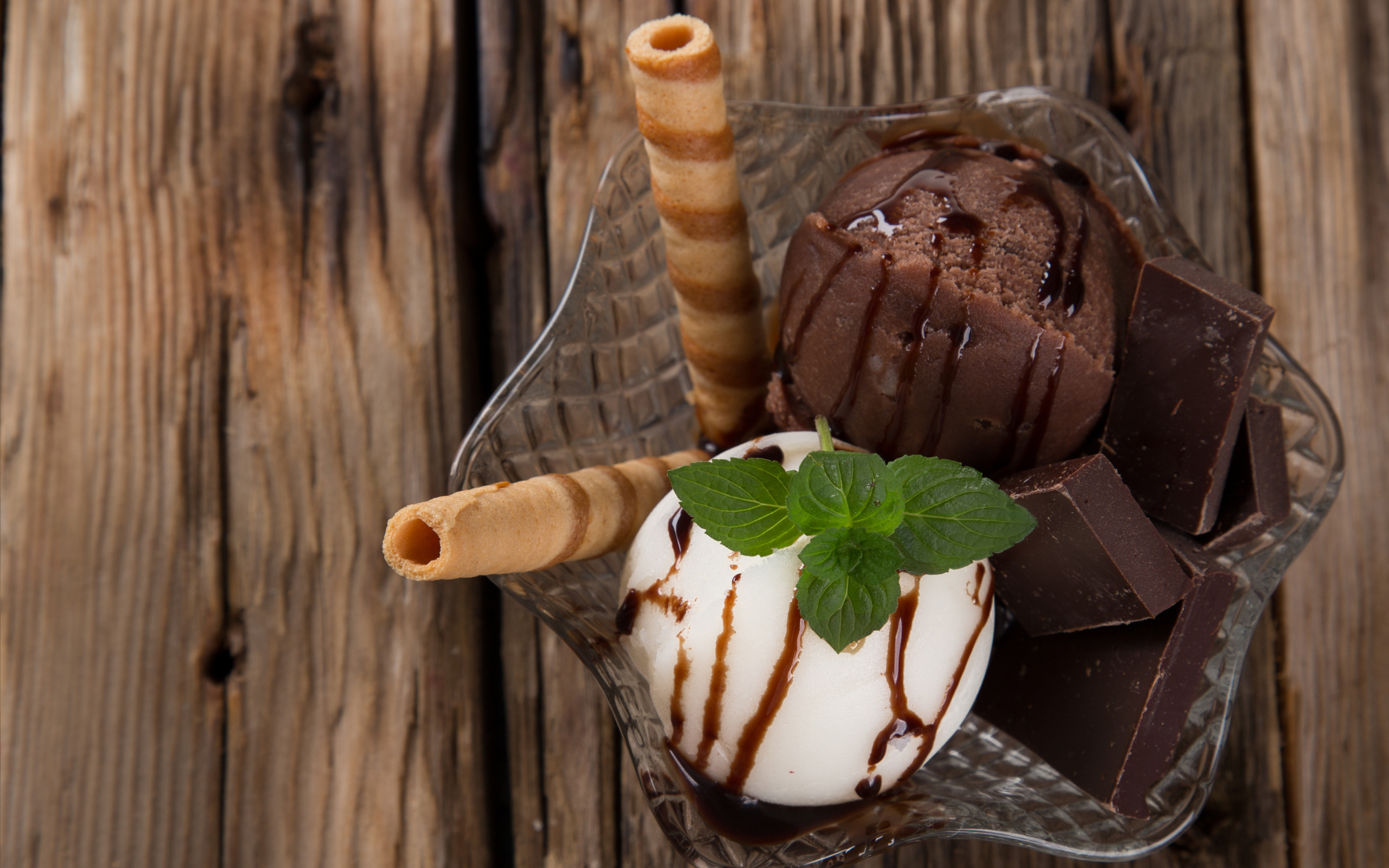 Шарик сливочного и шоколадного мороженого в пиале с трубочками
