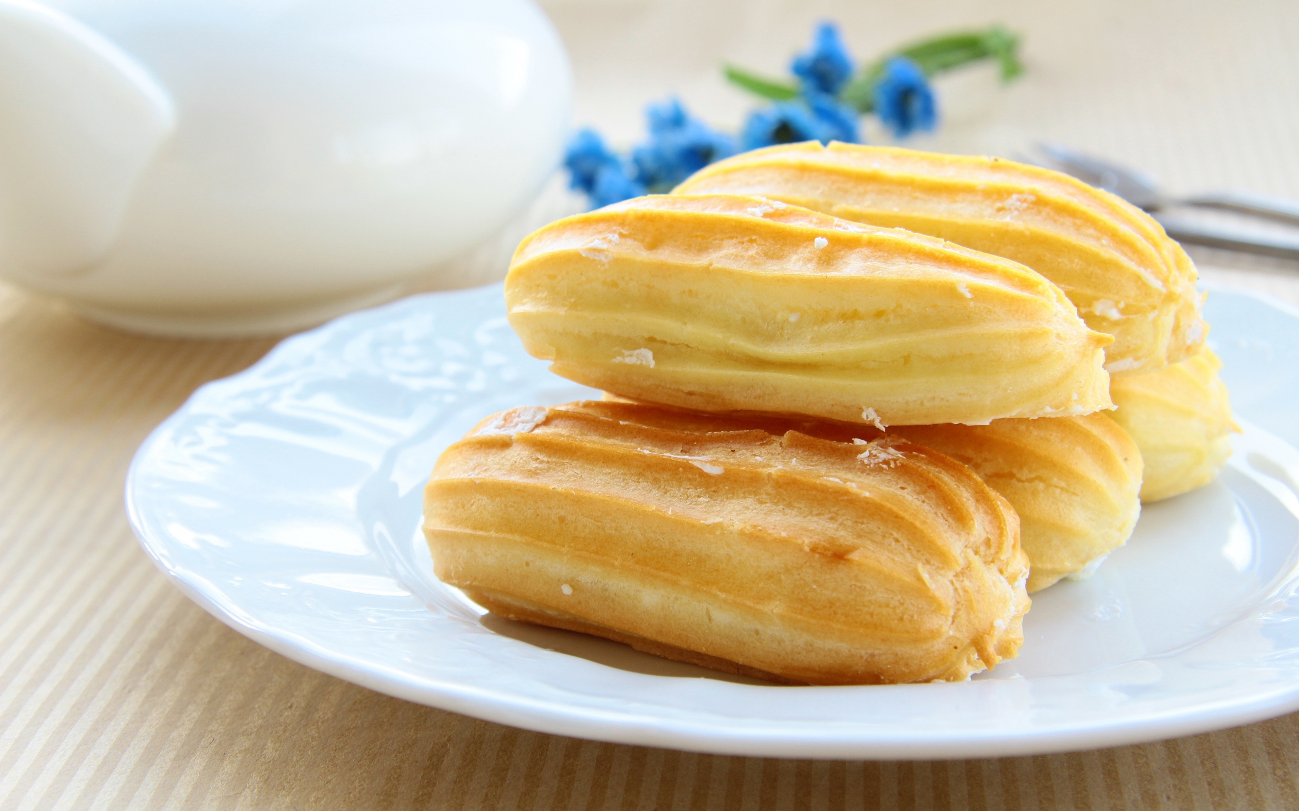 Заварные пирожные на большой белой тарелке 