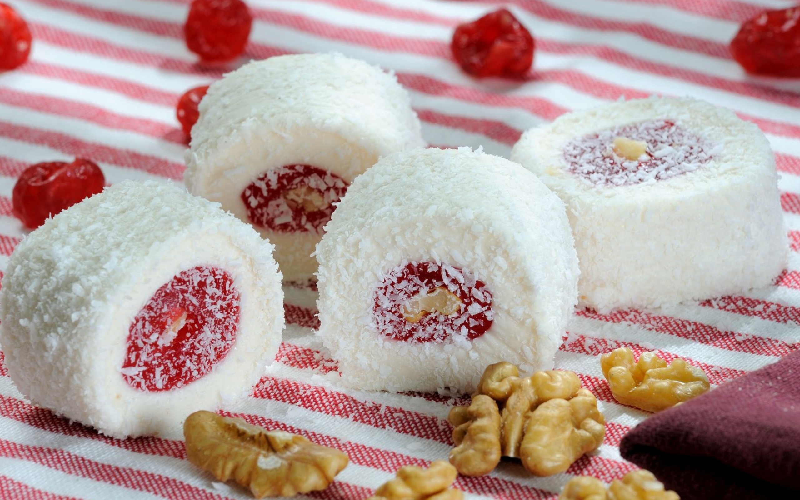 Десерт с джемом и кокосовой стружкой на столе с орехами