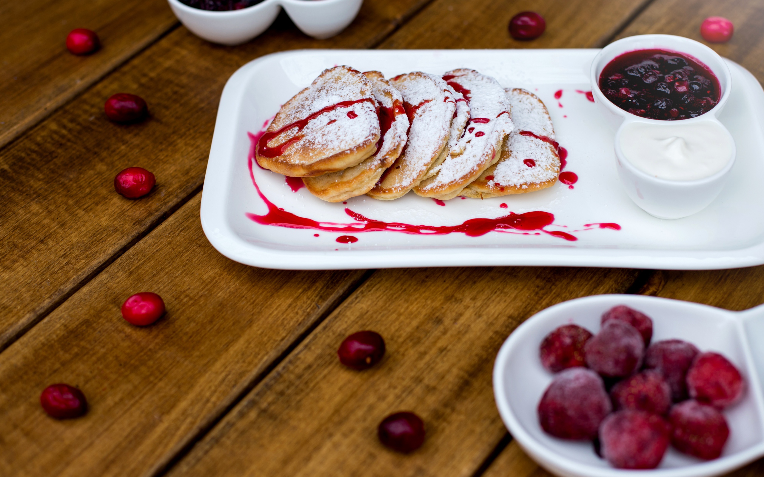 Оладьи с сахарной пудрой и вареньем на белой тарелке