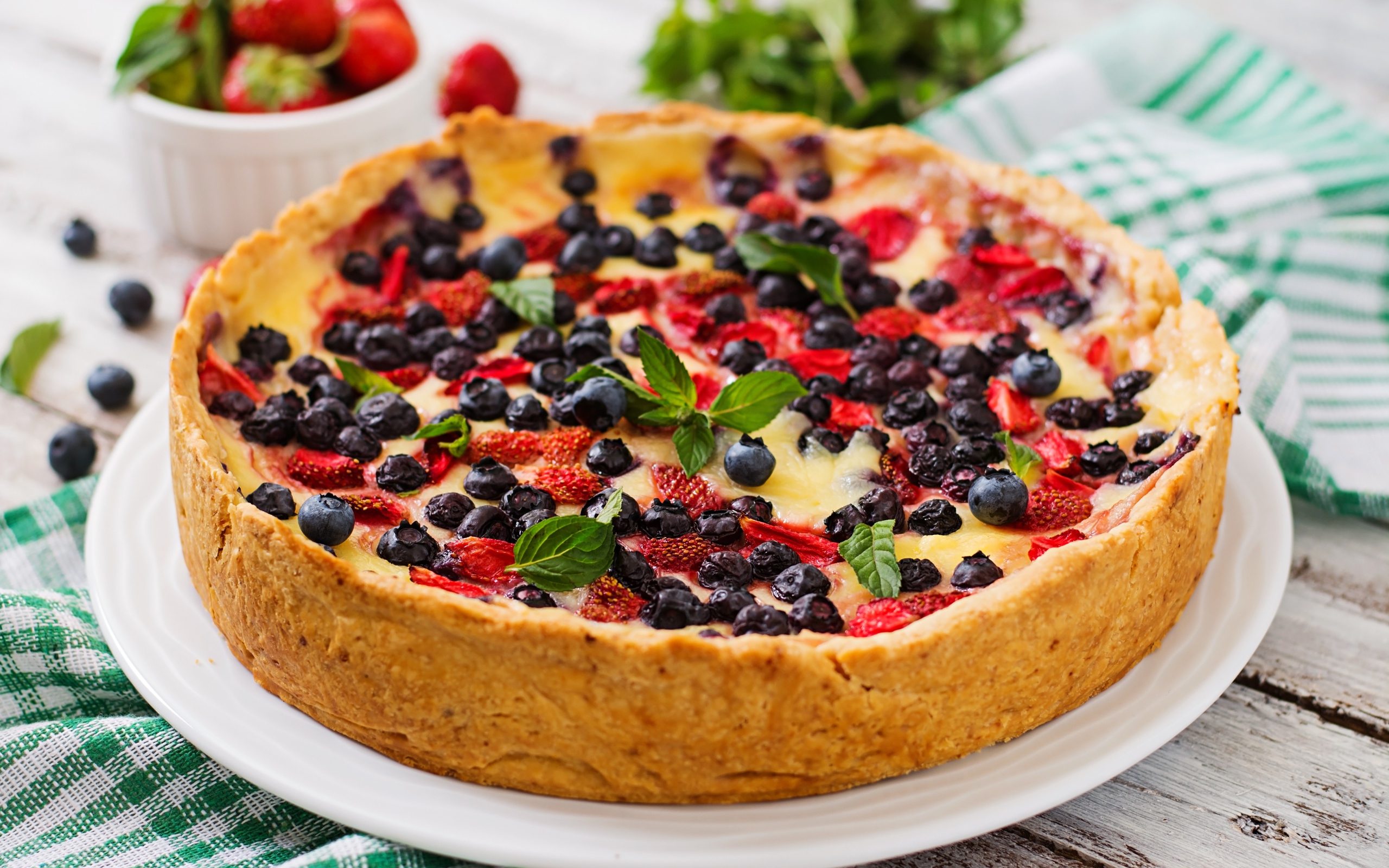 Сладкий пирог с черникой и клубникой на белом блюде