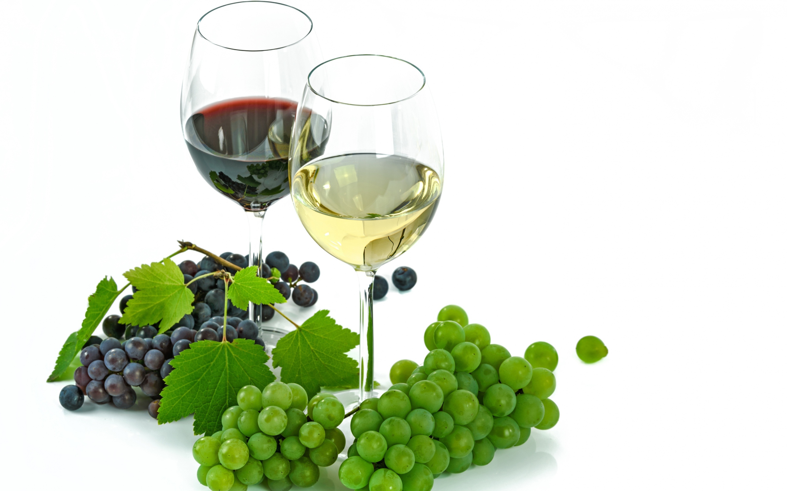 Бокал белого и красного вина на белом фоне с виноградом
