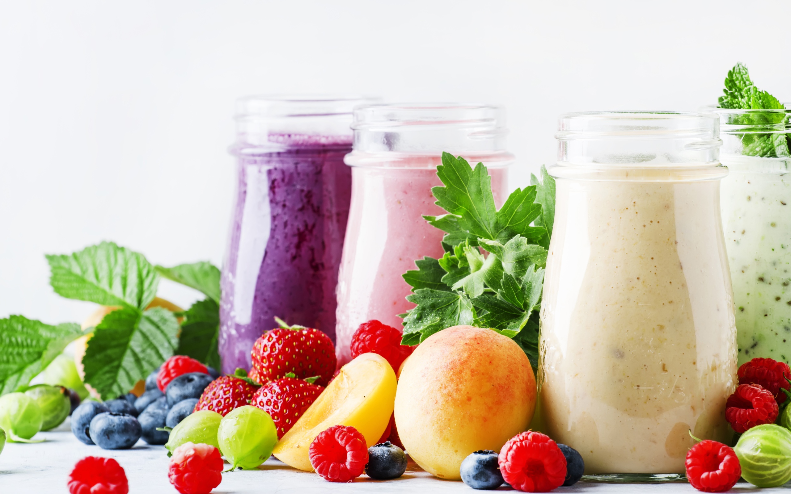 Ягодные смузи в бутылочках на столе с ягодами